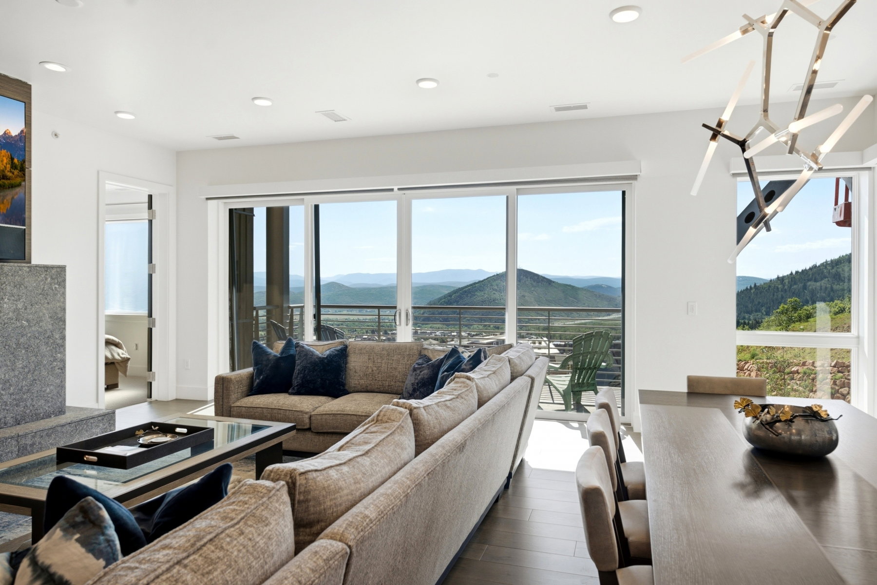Spacious living area featuring expansive sliding glass doors, a large picture window, recessed lighting, and dark wood-finish flooring