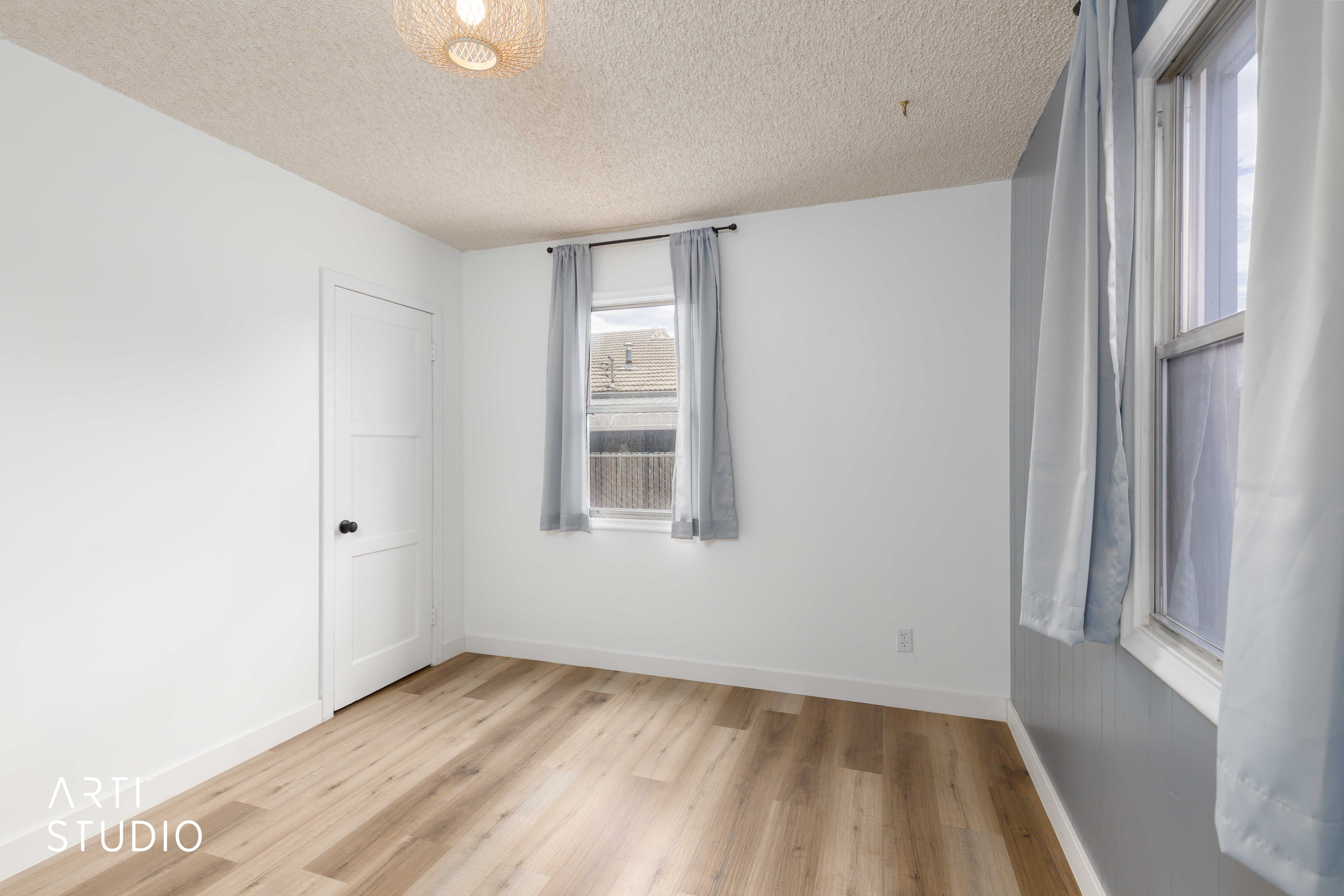 Light wood-finish flooring complements white walls with matching trim