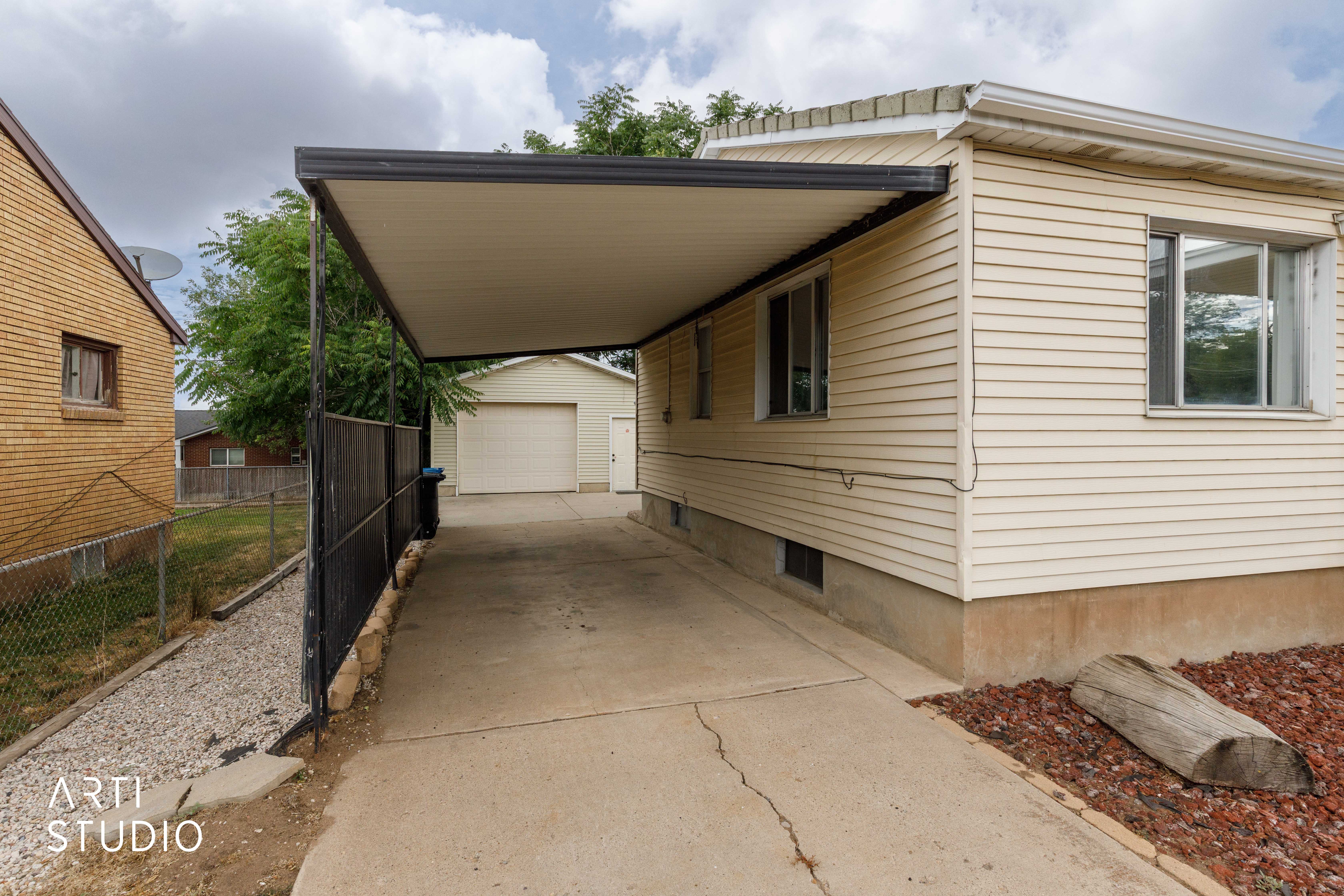Covered carport extending to a detached garage