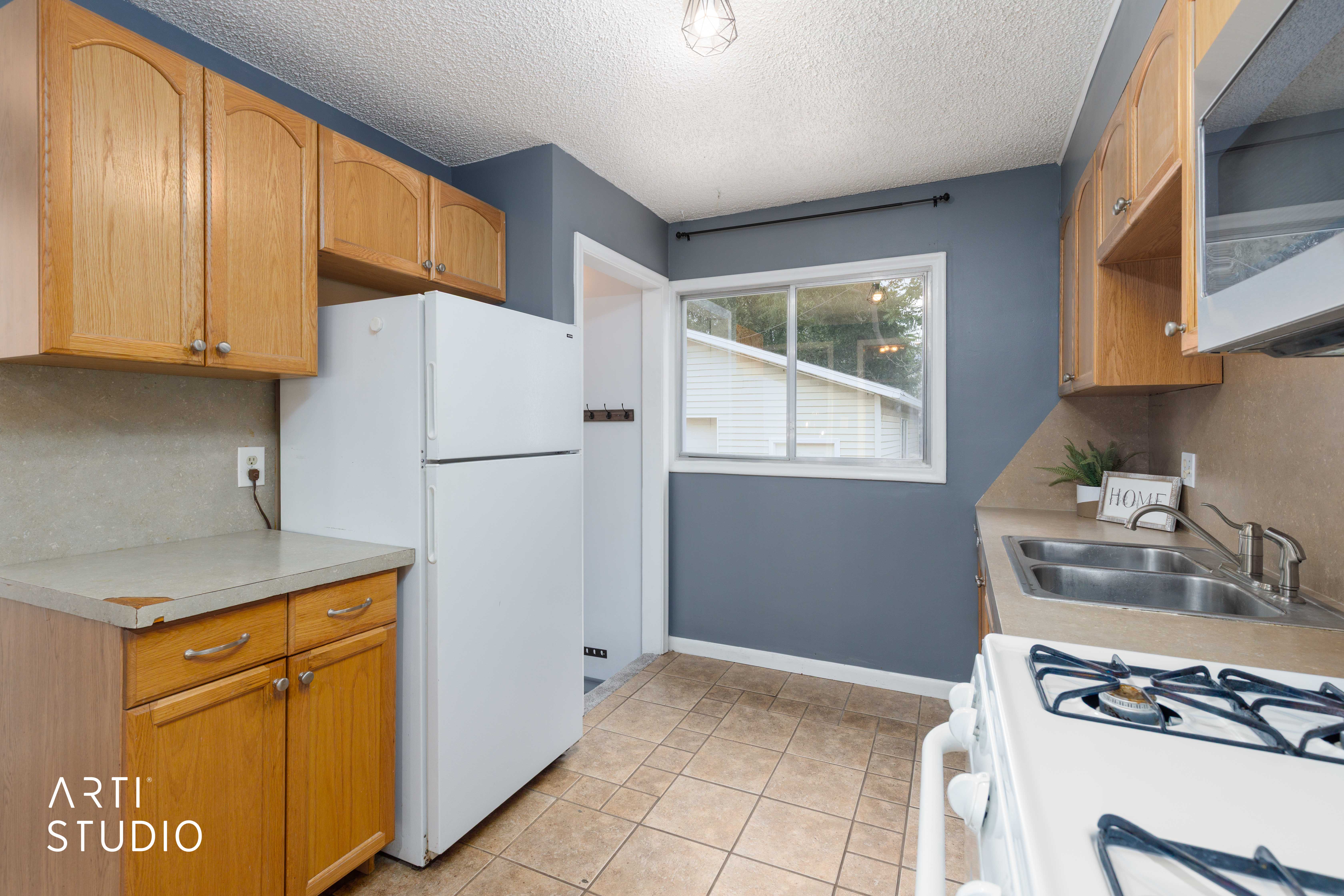 Kitchen featuring wood cabinetry, tile flooring, and a double basin sink