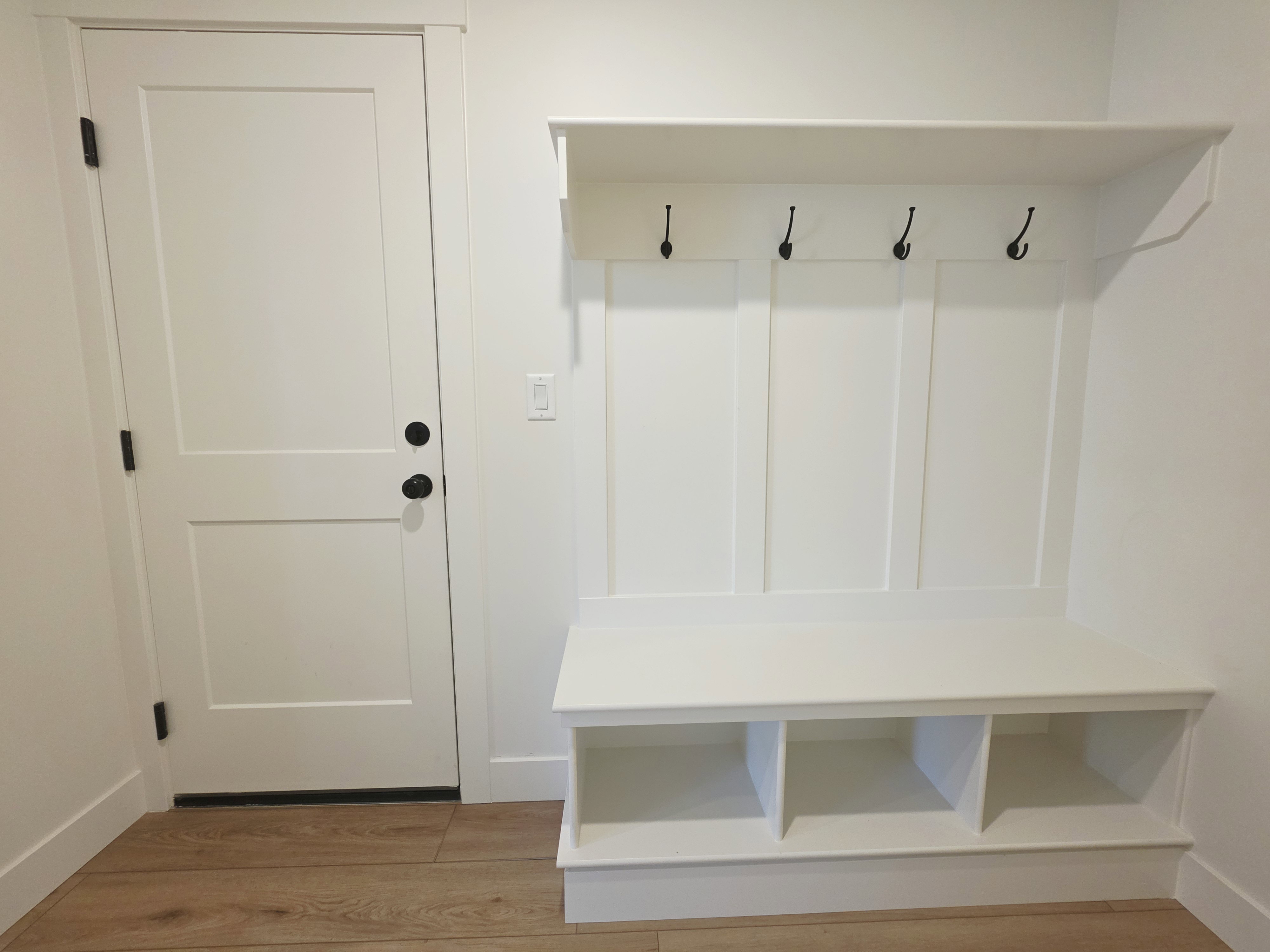Built-in entryway bench with storage cubbies and upper shelving