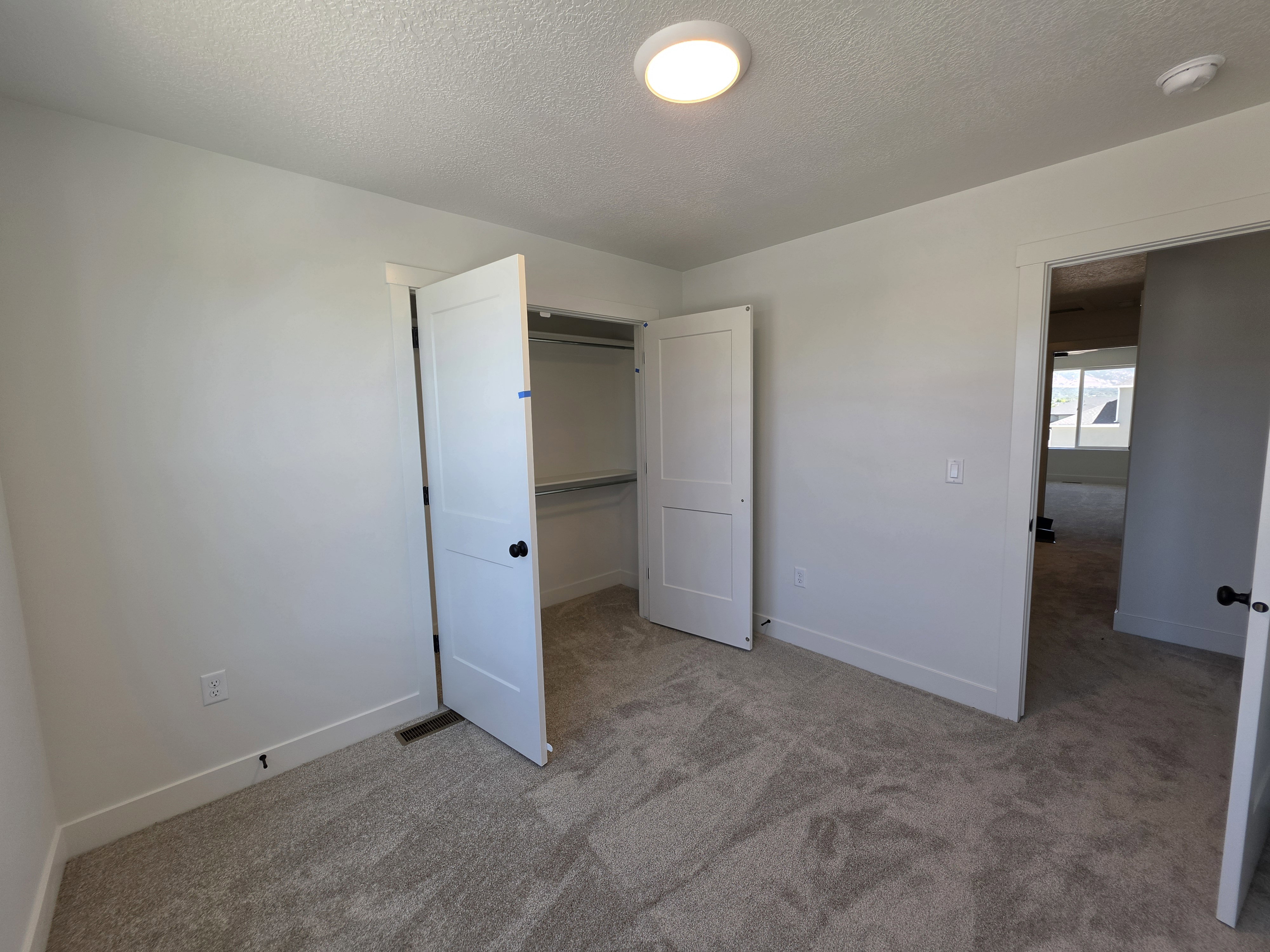 Carpeted interior room with a ceiling-mounted light fixture