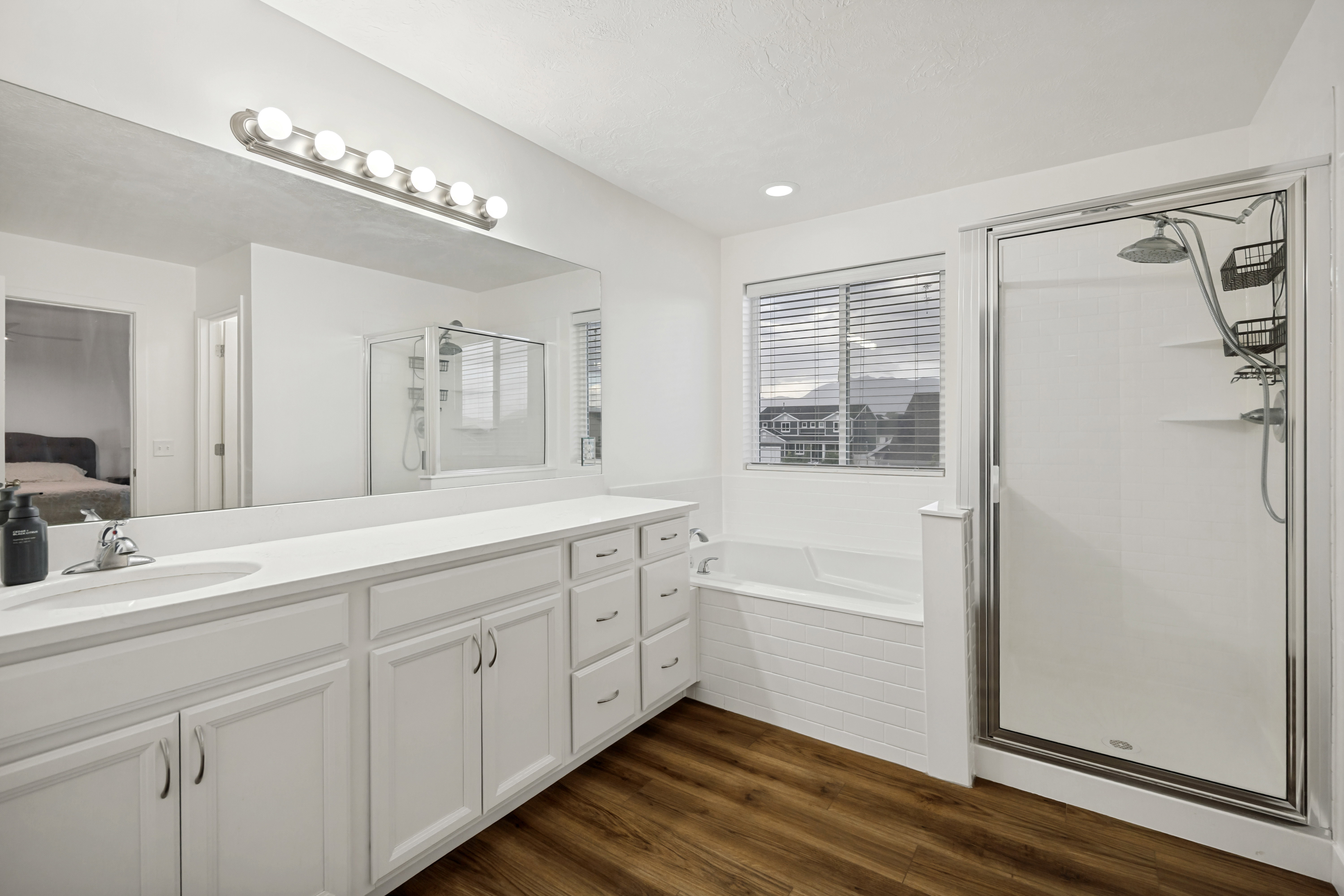Bathroom featuring a dual vanity with white cabinetry and a full-width mirror