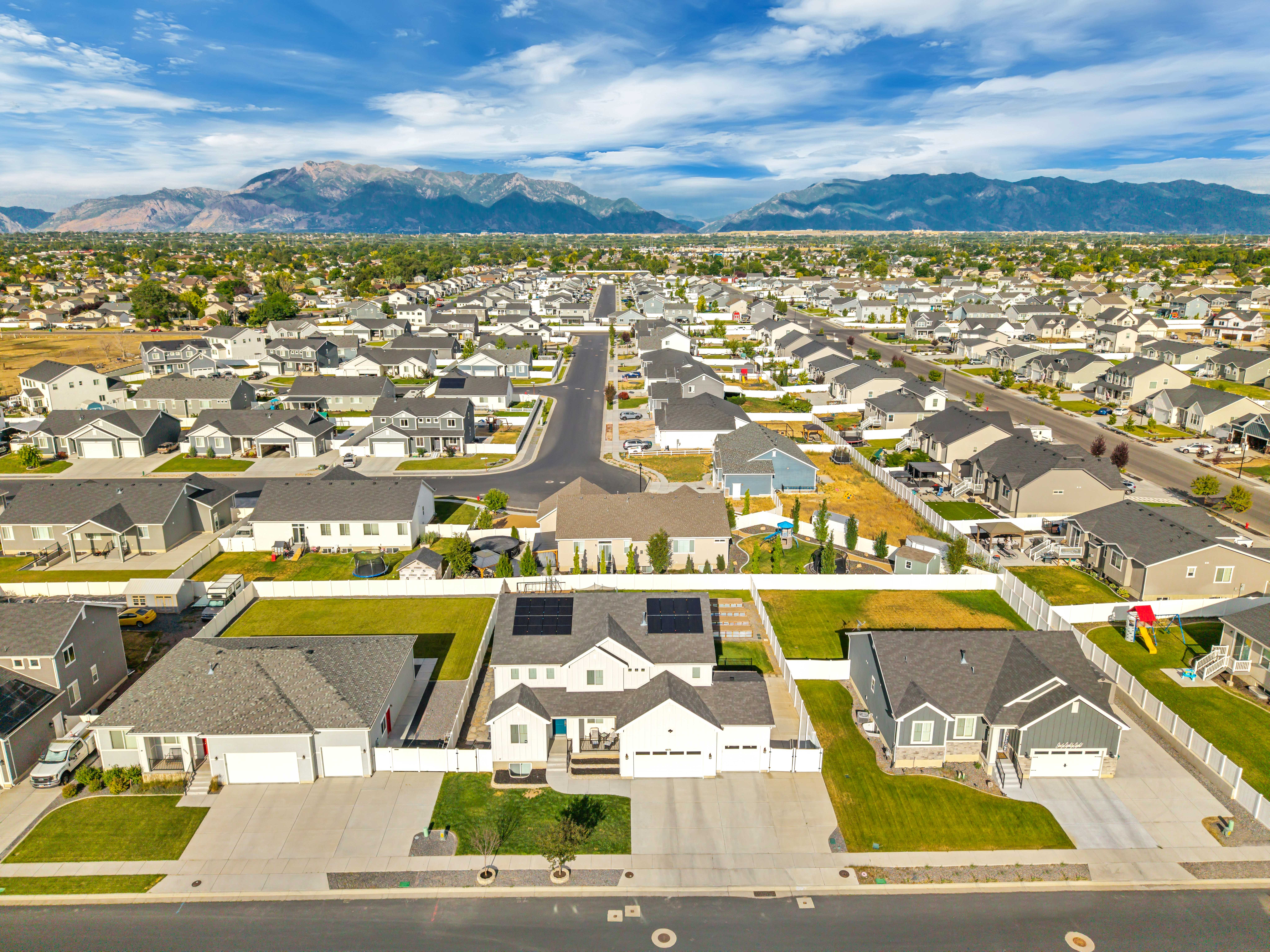 Expansive aerial perspective showcasing a residential neighborhood with distant mountains