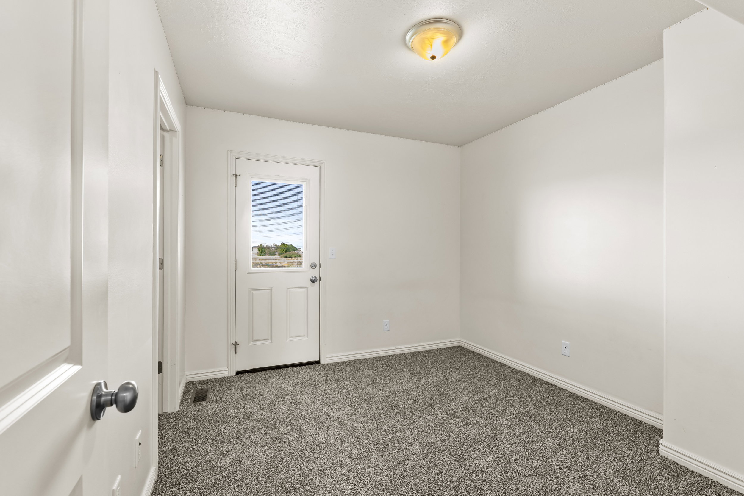 Neutral tone wall finish with a white trim, complemented by a semi-flush mount ceiling light fixture