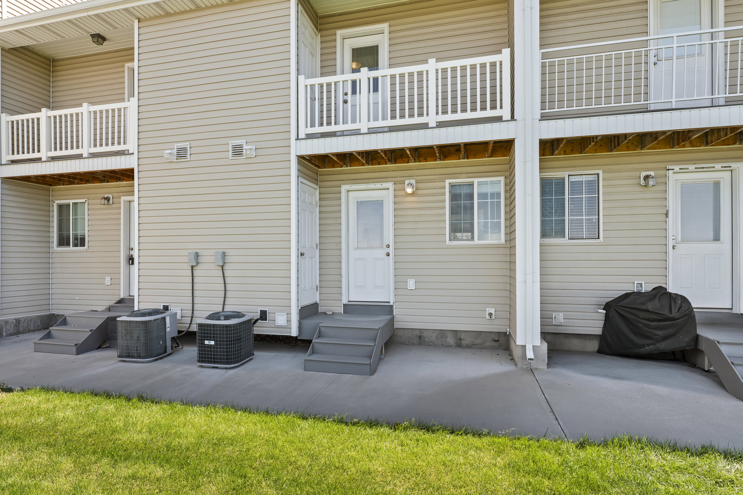 Multi-level exterior featuring tan vinyl siding and white trim