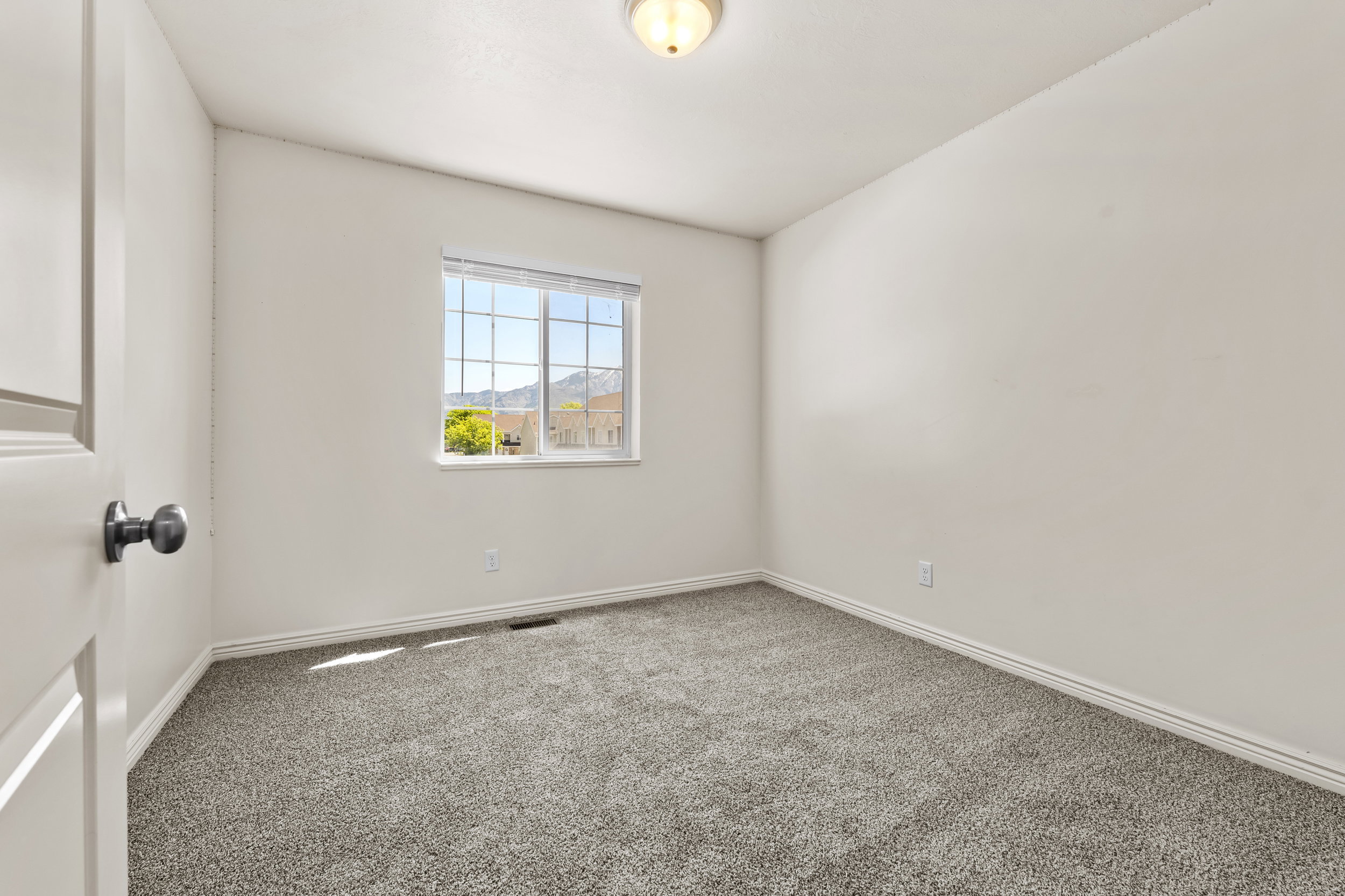Neutral wall tones and plush gray carpeting create a versatile interior
