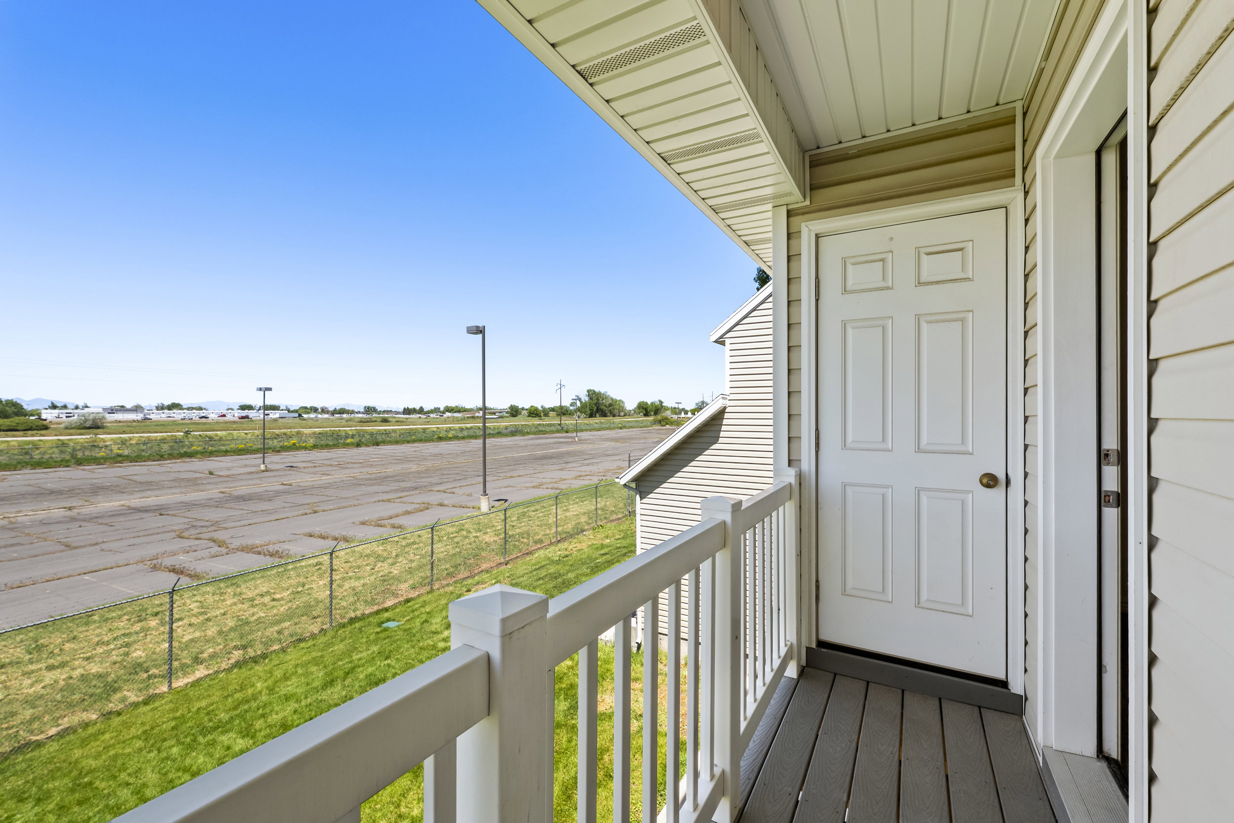 Private outdoor balcony featuring composite decking and white railing