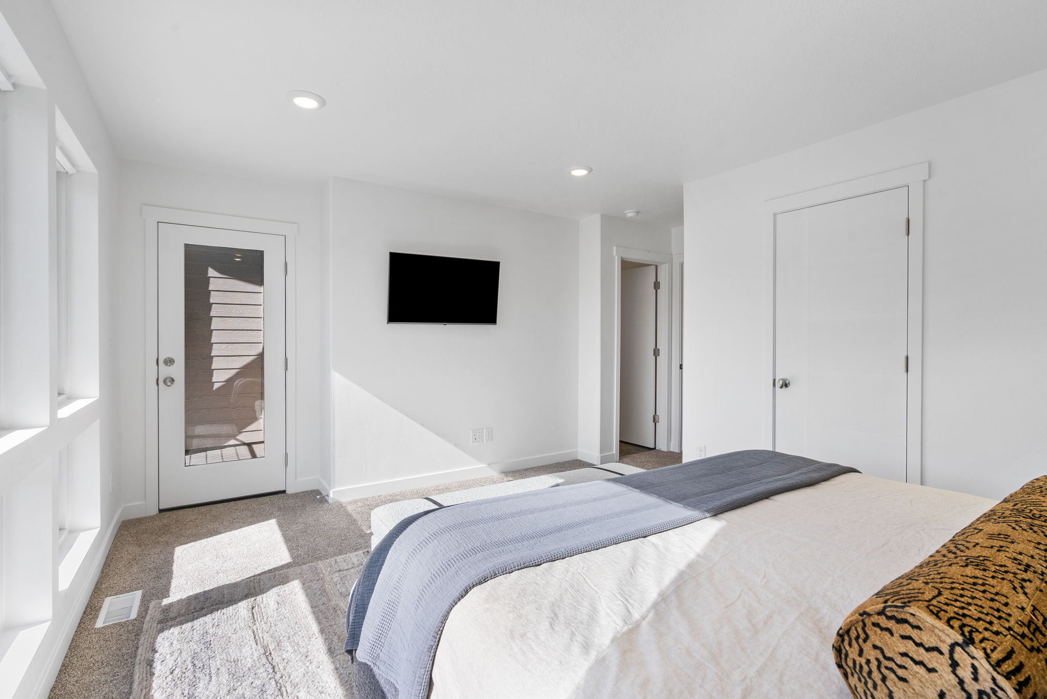 Bright room with recessed lighting and neutral carpet