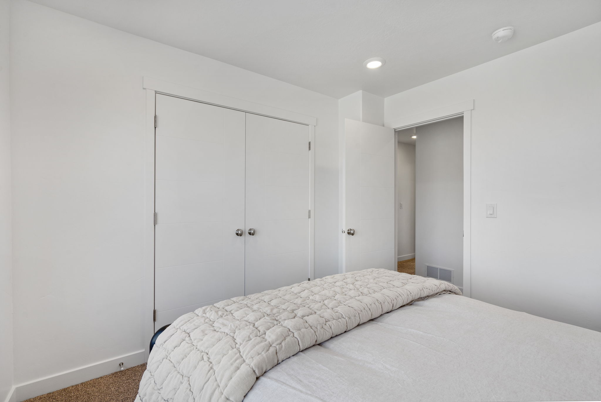 Bedroom featuring a neutral wall color, recessed lighting, and a closet with bifold doors and spherical hardware
