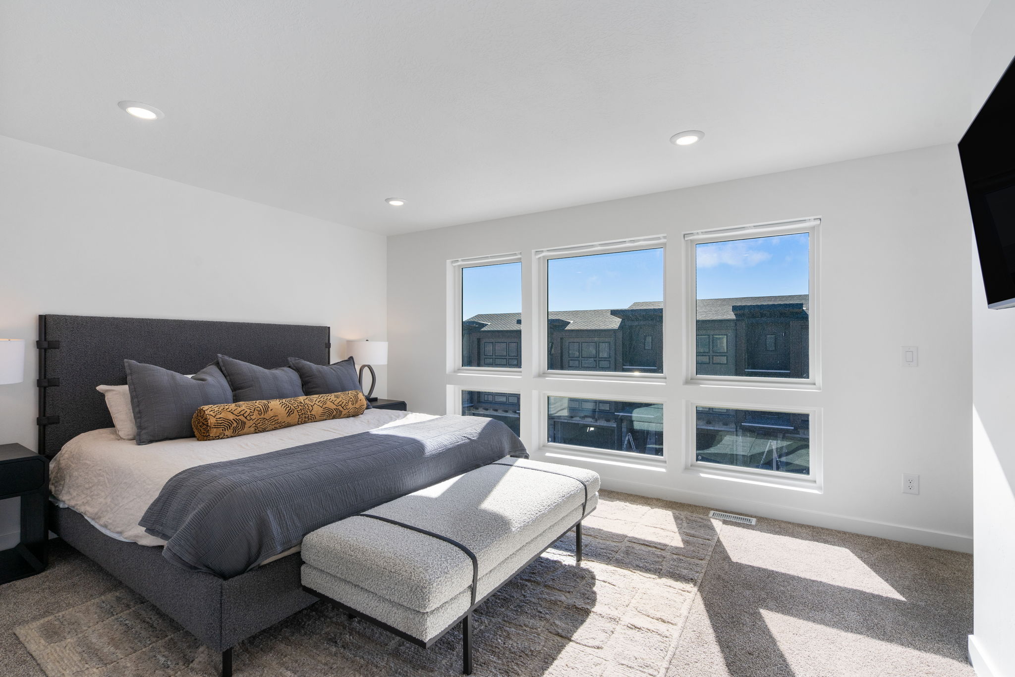 Spacious room featuring multiple large windows, recessed lighting, and light-toned carpeting