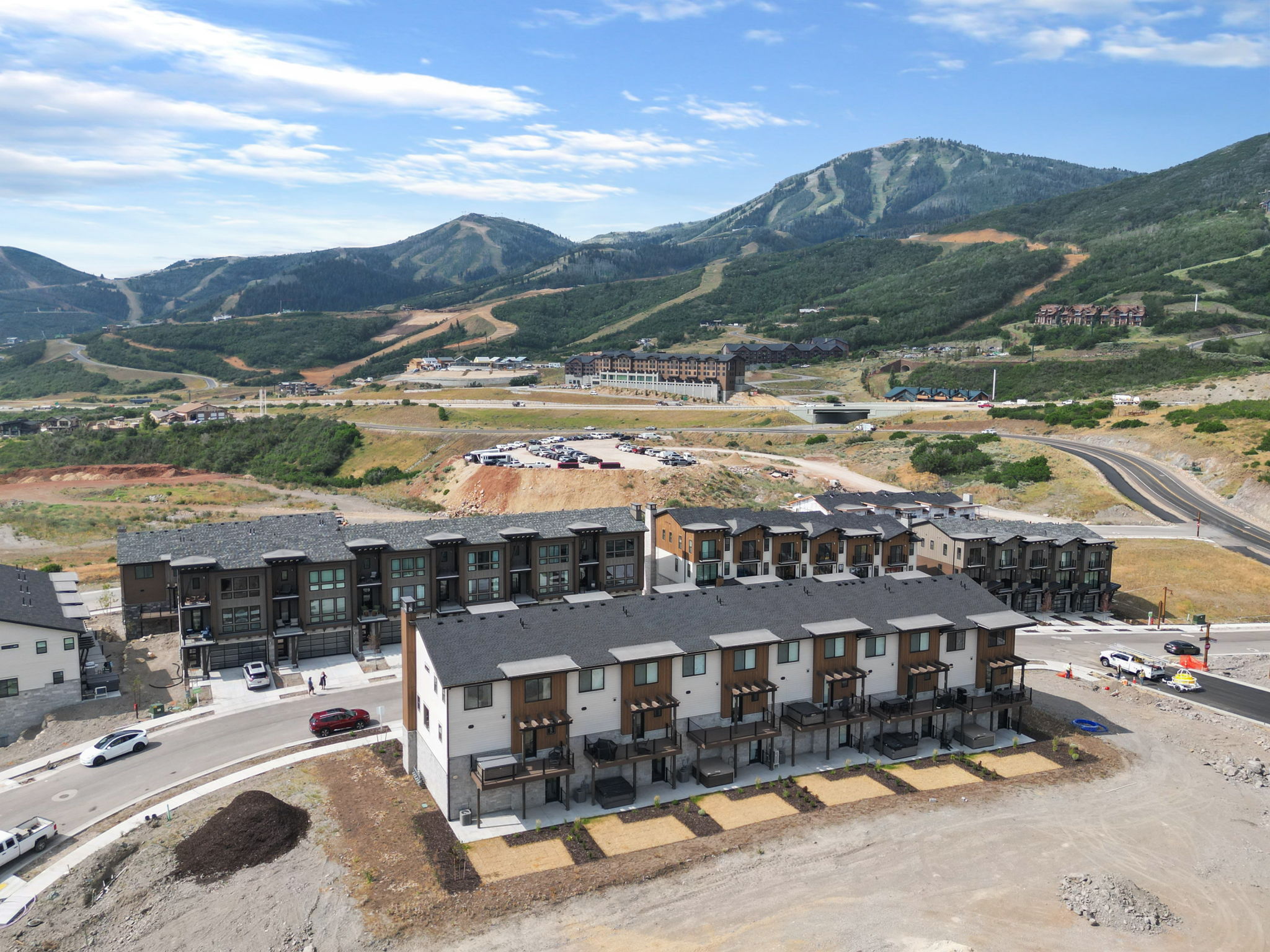 Modern multi-story townhomes with stone and wood-look siding exteriors