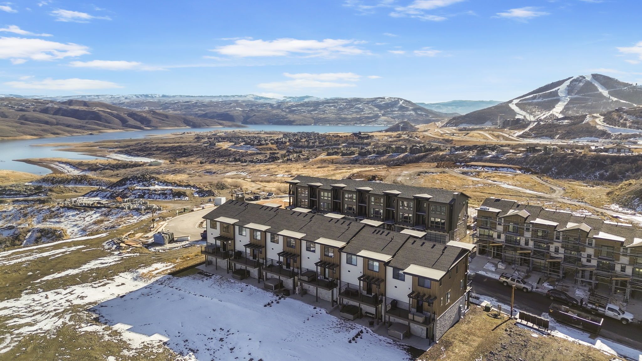 Modern multi-story townhomes featuring balconies, dark framed windows, and a mix of light and dark siding