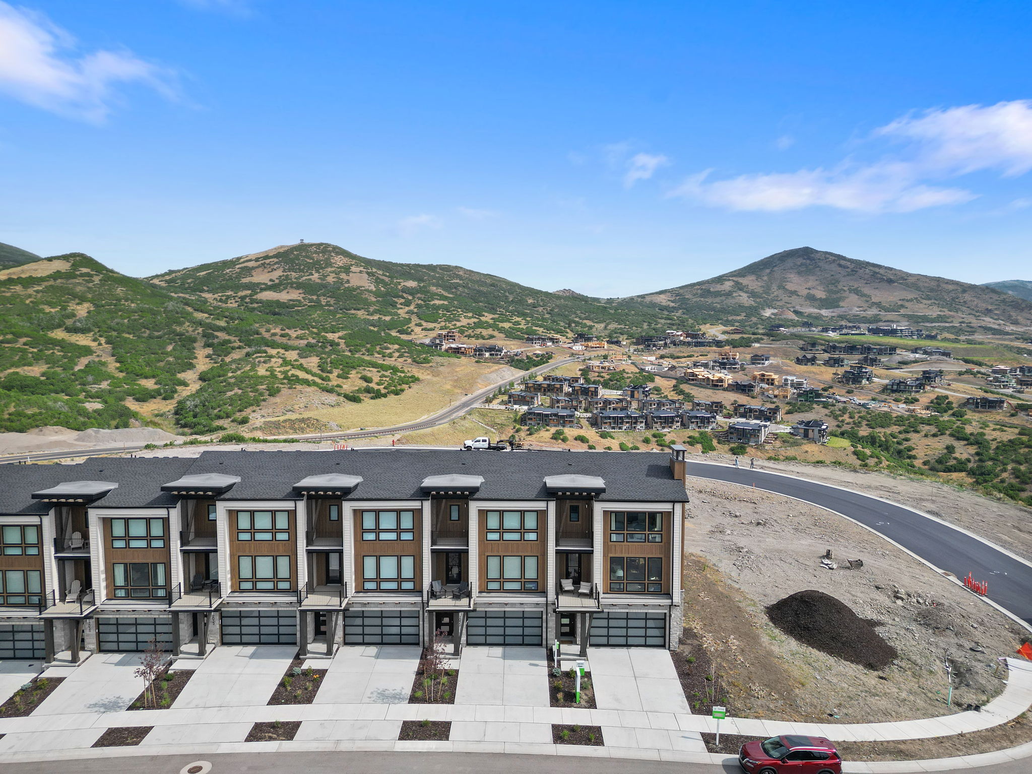 Modern townhomes featuring a multi-story design with wood-finish siding and dark trim