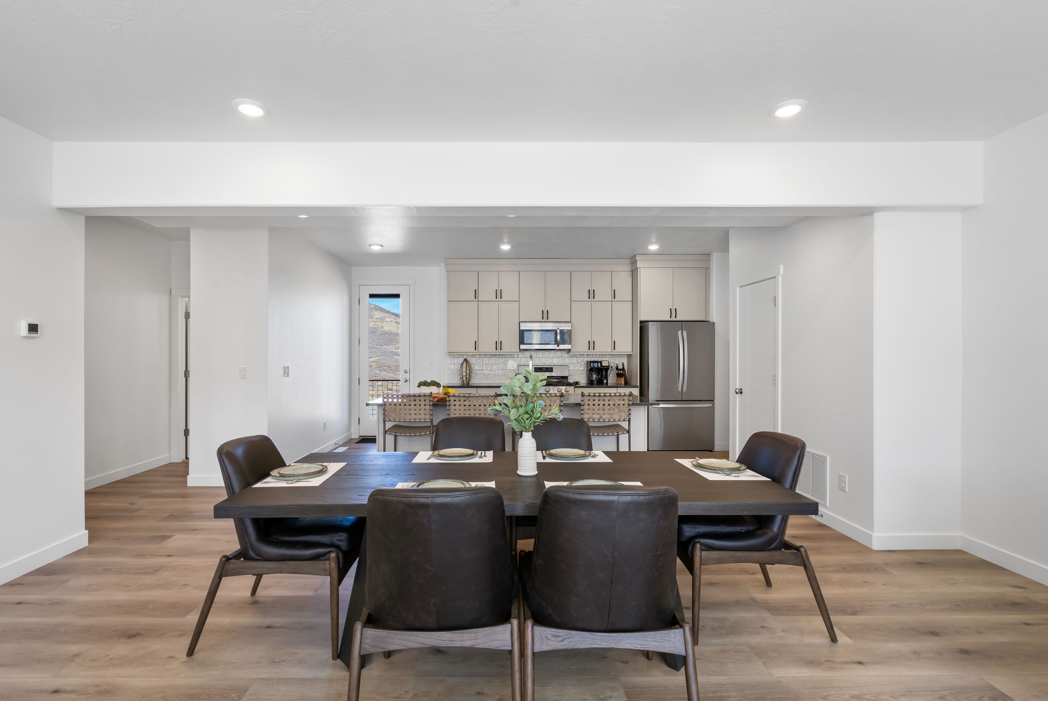 Open-concept dining area featuring wood-finish flooring, recessed lighting, and a neutral color palette