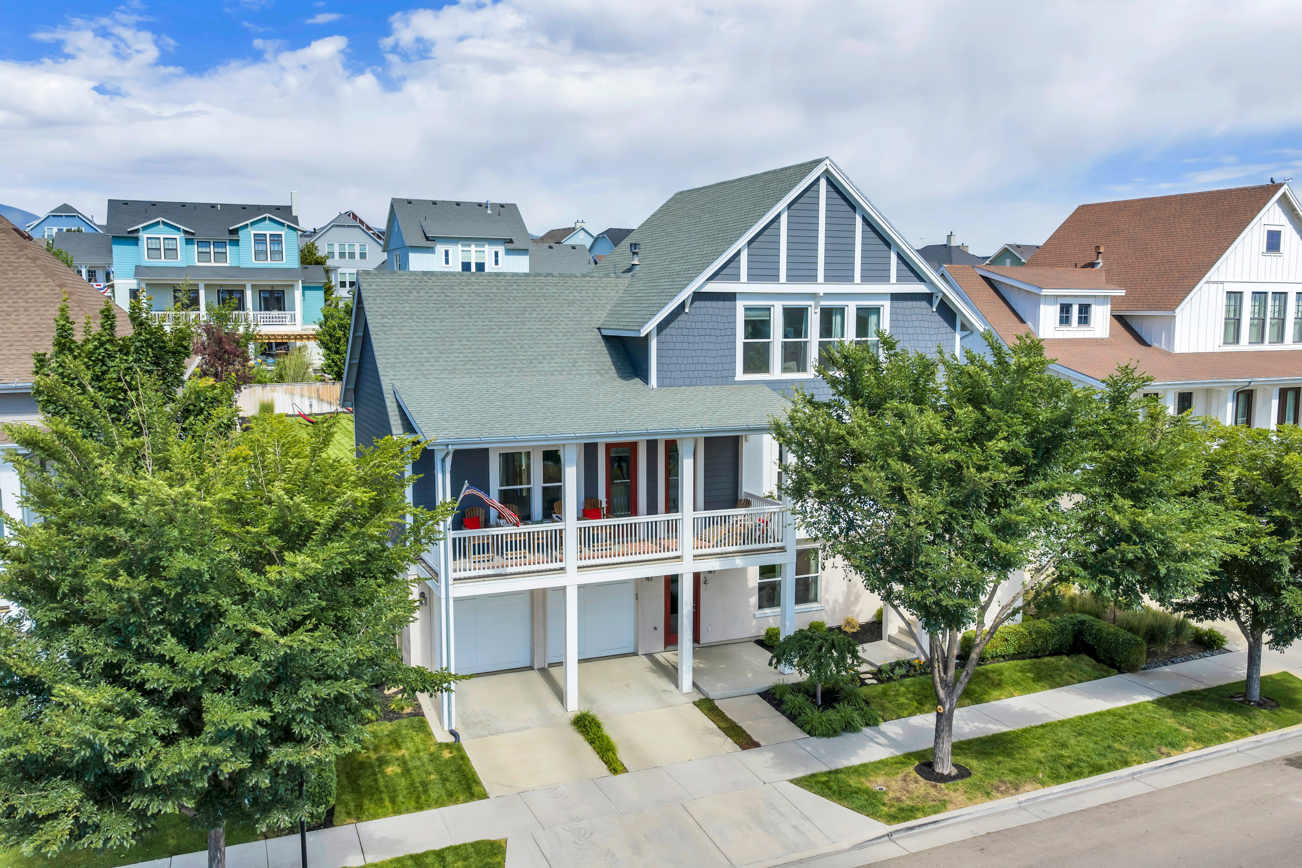 Two-story residence featuring a shingled roof and shiplap siding