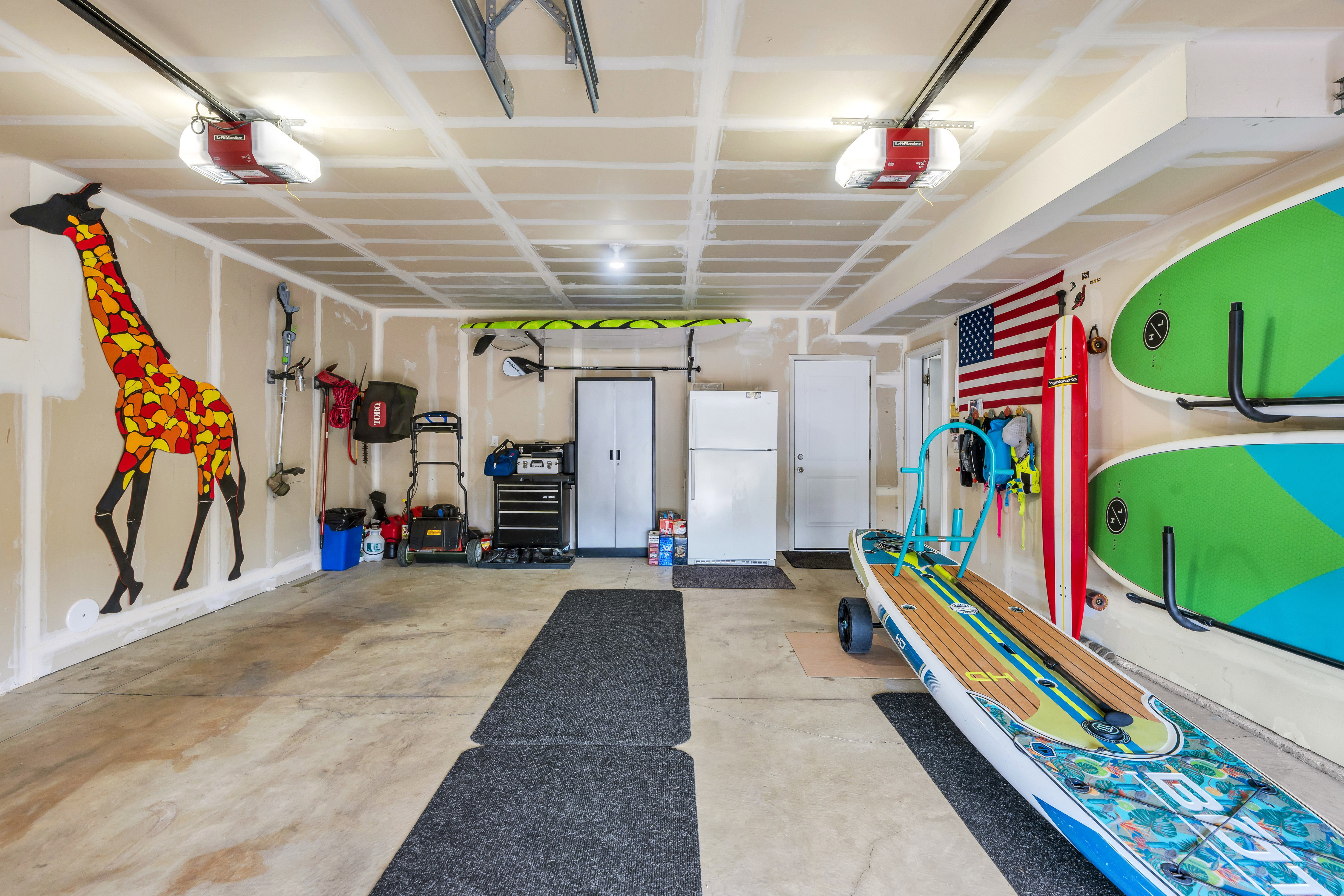 Spacious garage with concrete flooring, two automatic garage door openers, and recessed ceiling lighting