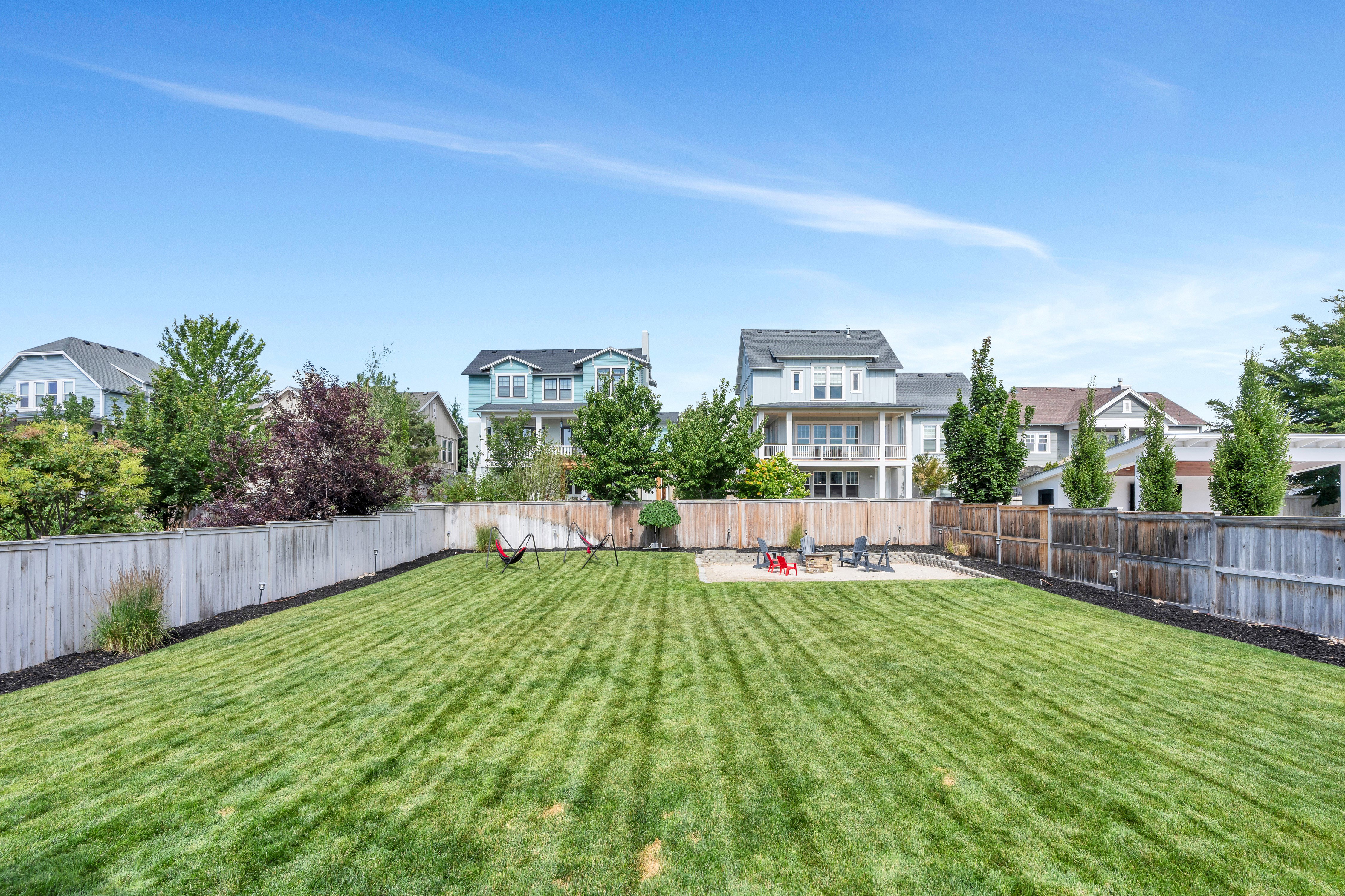Expansive green lawn framed by a combination of light and dark wood fencing