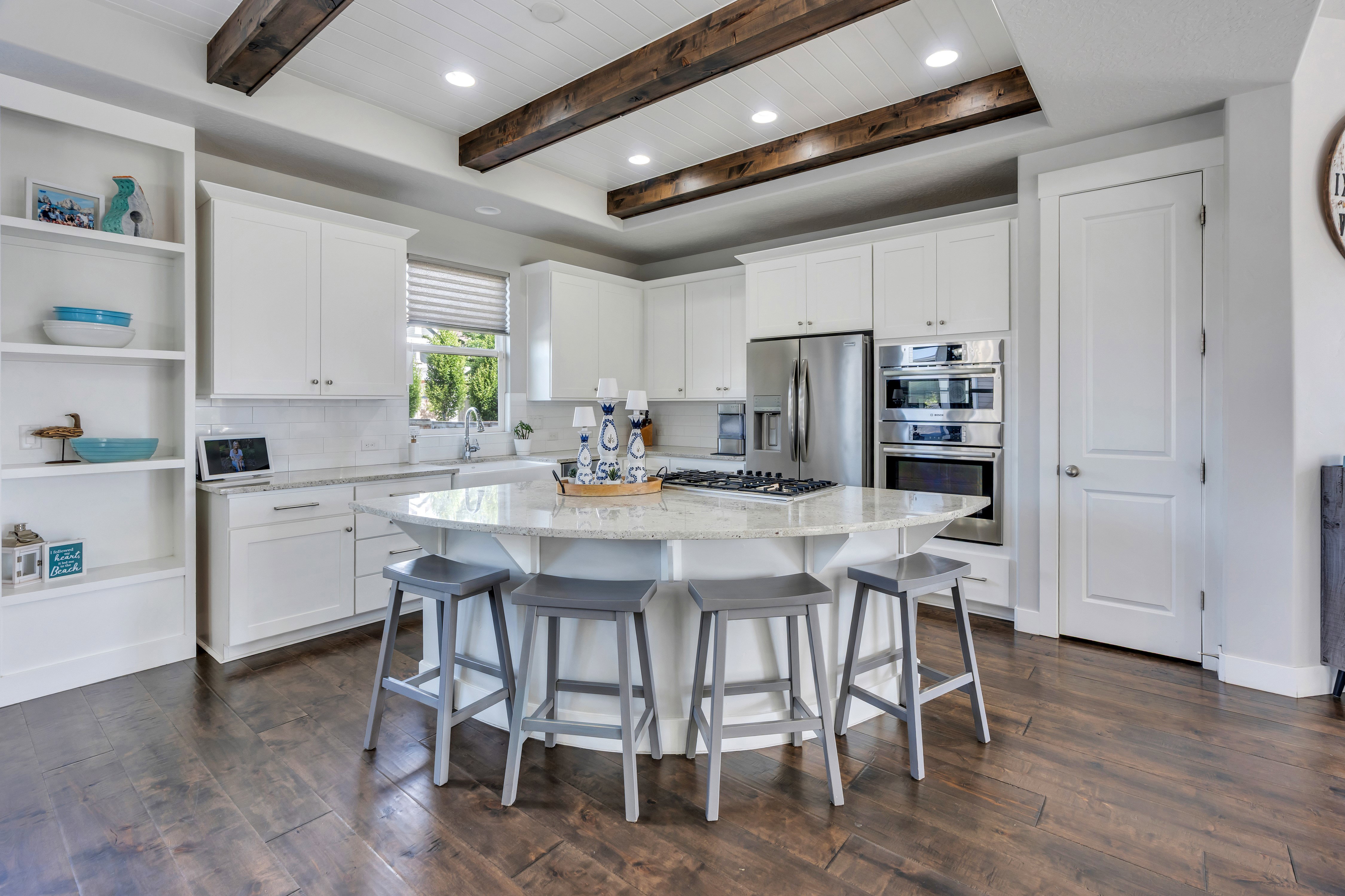 Kitchen featuring white cabinetry, a central island with countertop seating, stainless steel appliances, and a wood-finish floor