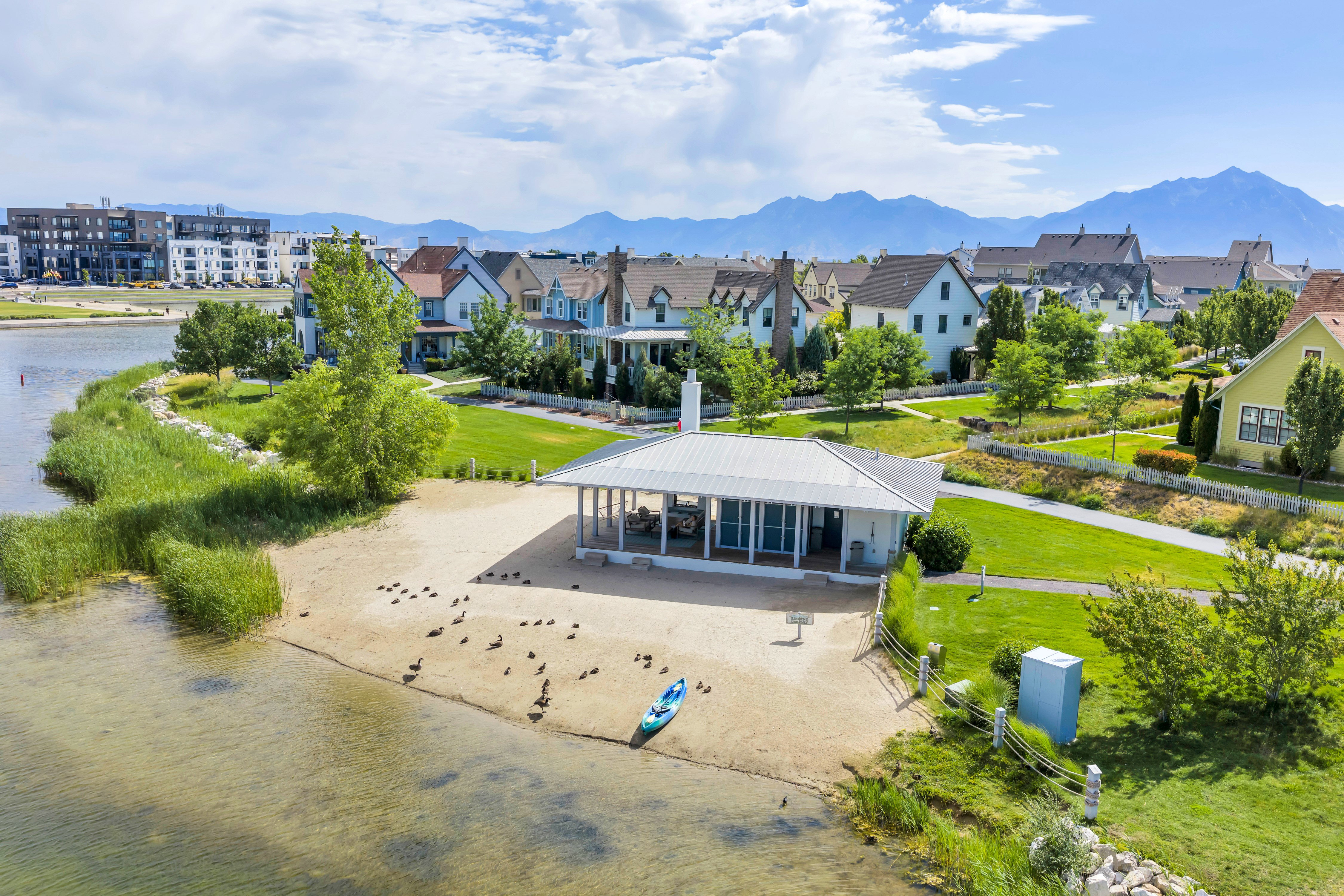 Waterfront setting featuring a sandy beach area with a covered pavilion structure