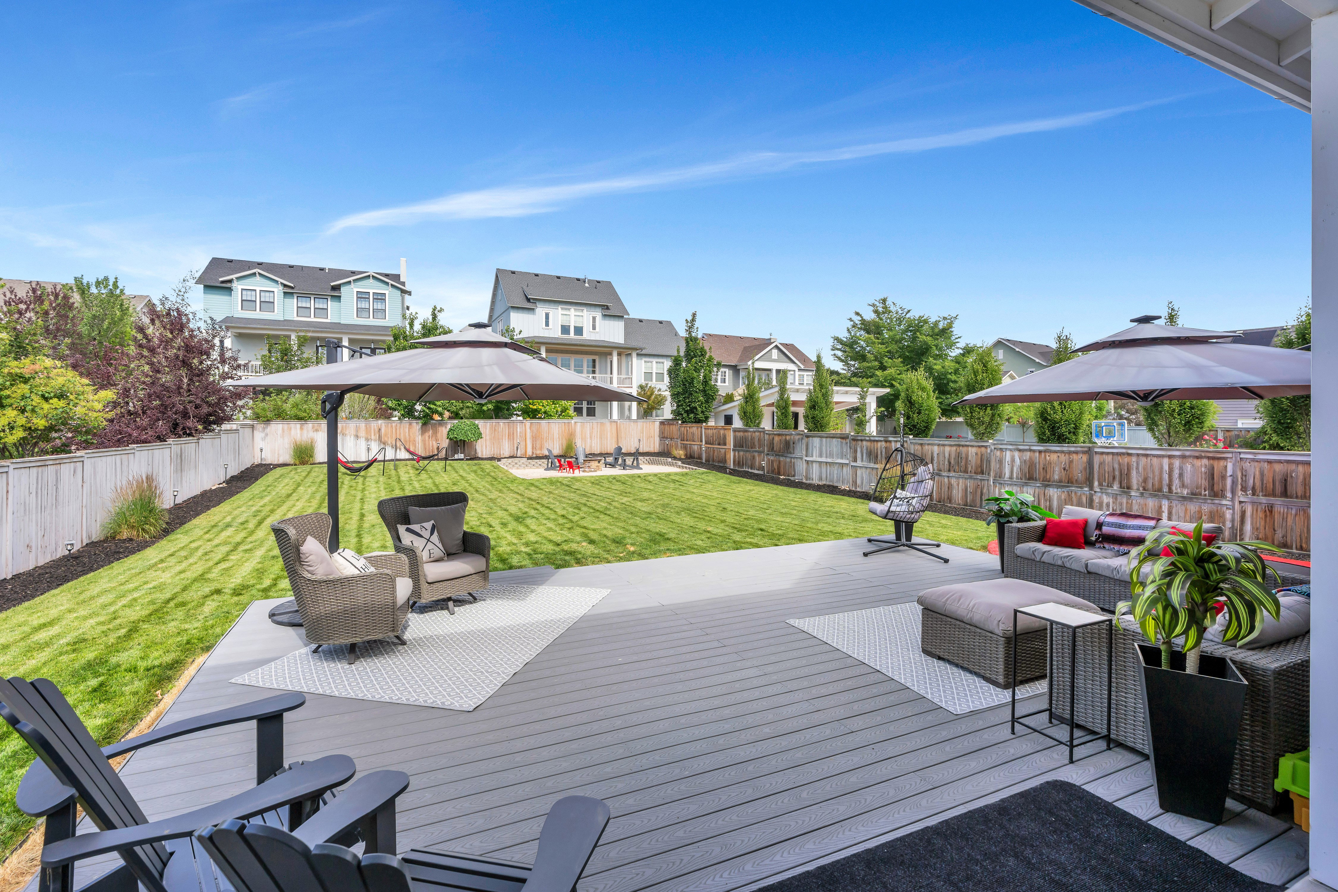 Expansive backyard featuring a composite deck, large lawn, and privacy fencing