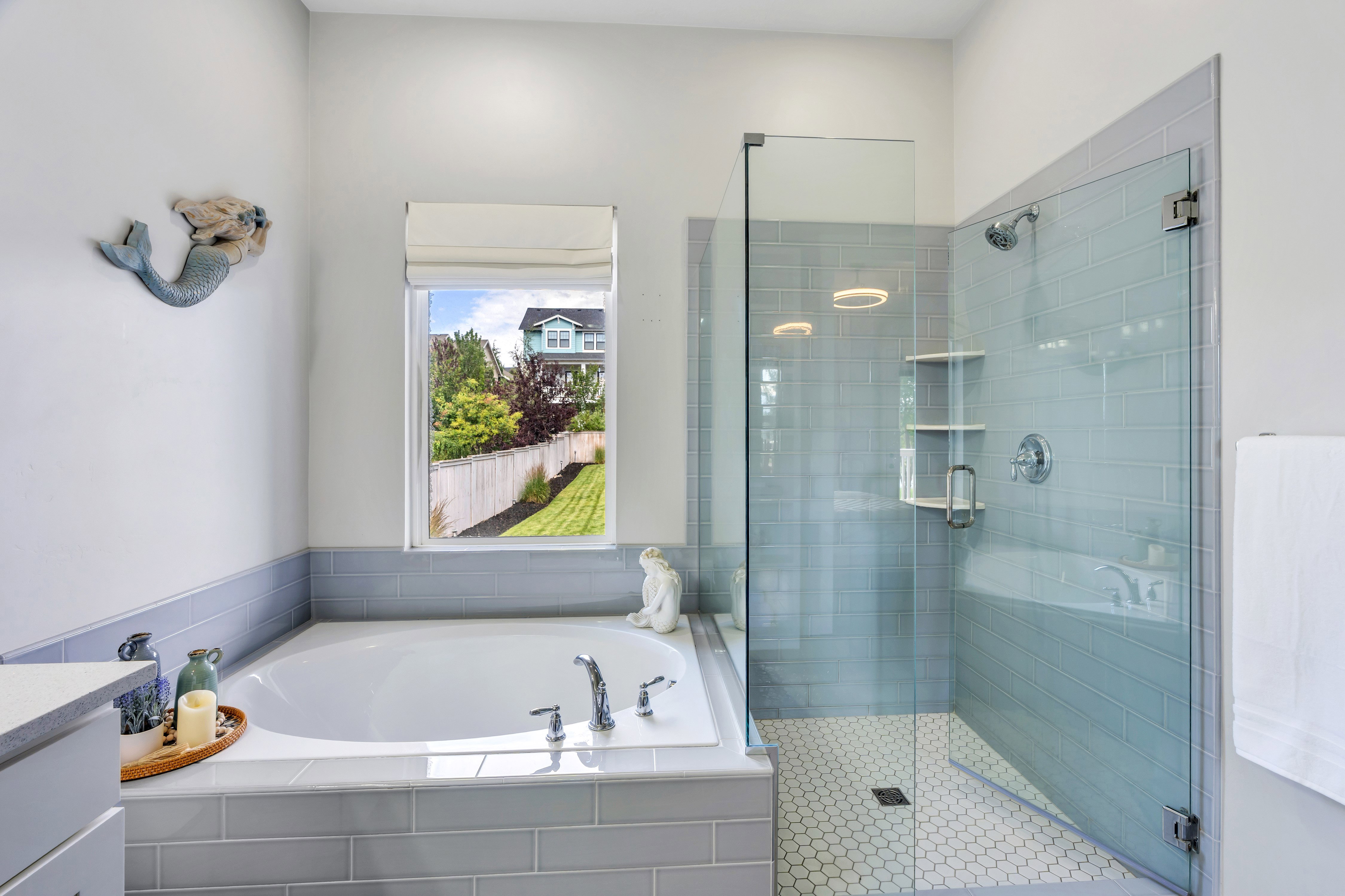 Bathroom featuring a built-in soaking tub, clear glass shower enclosure, subway tile shower surround, and hexagonal tile shower flooring
