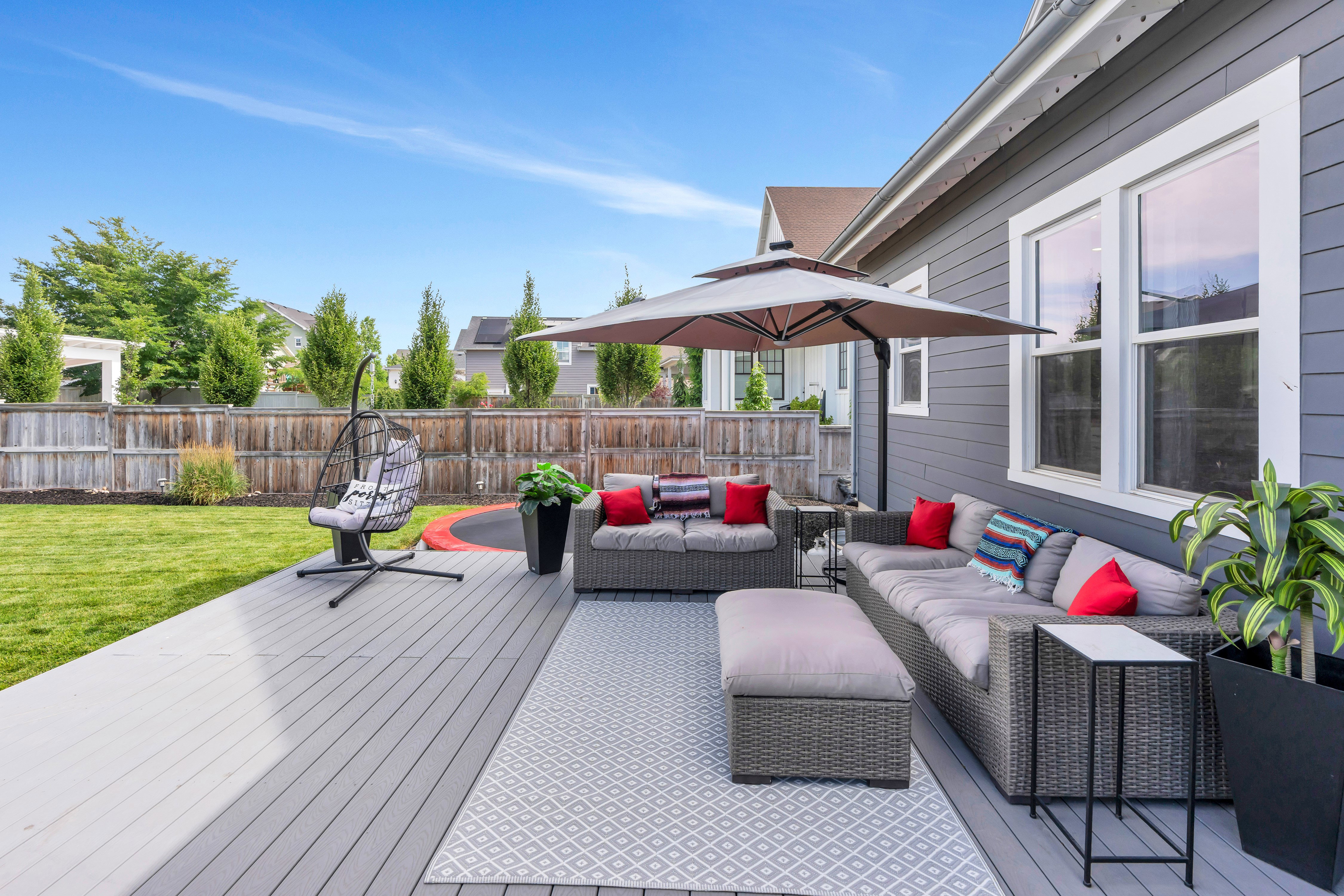 Expansive backyard featuring a composite deck, manicured lawn, and privacy fencing
