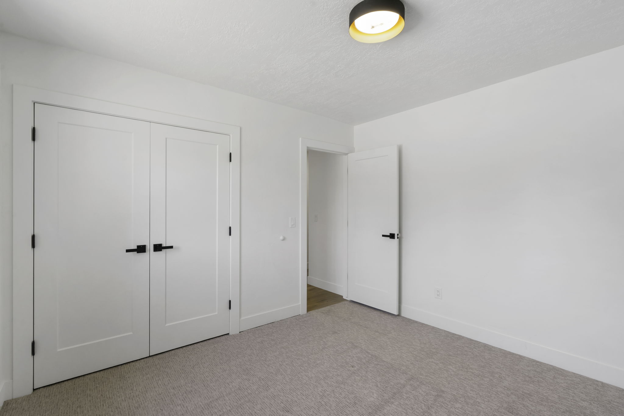 Neutral tone carpeting complemented by white walls and trim