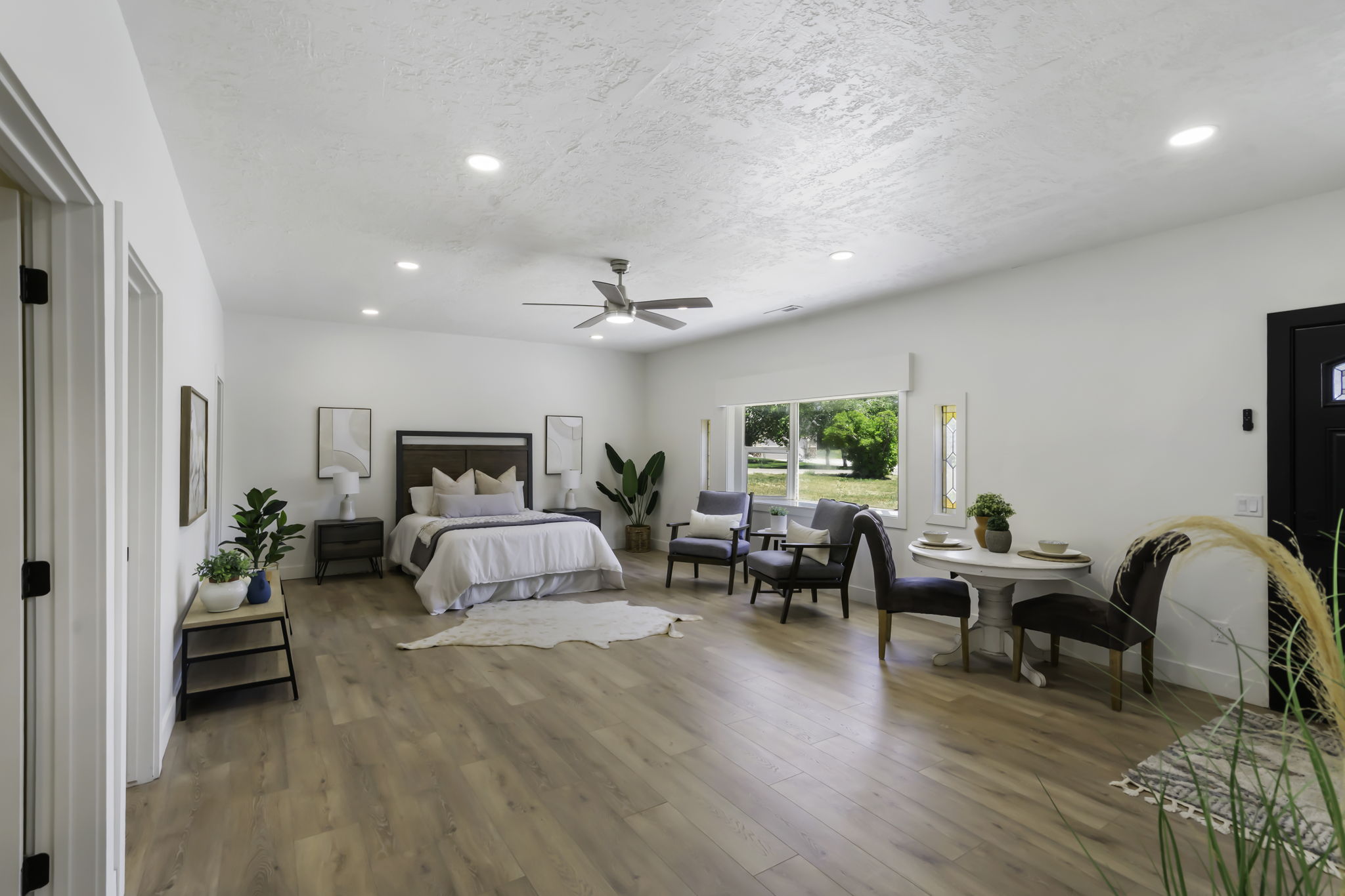 Spacious bedroom featuring light wood-finish flooring, recessed lighting, and a ceiling fan