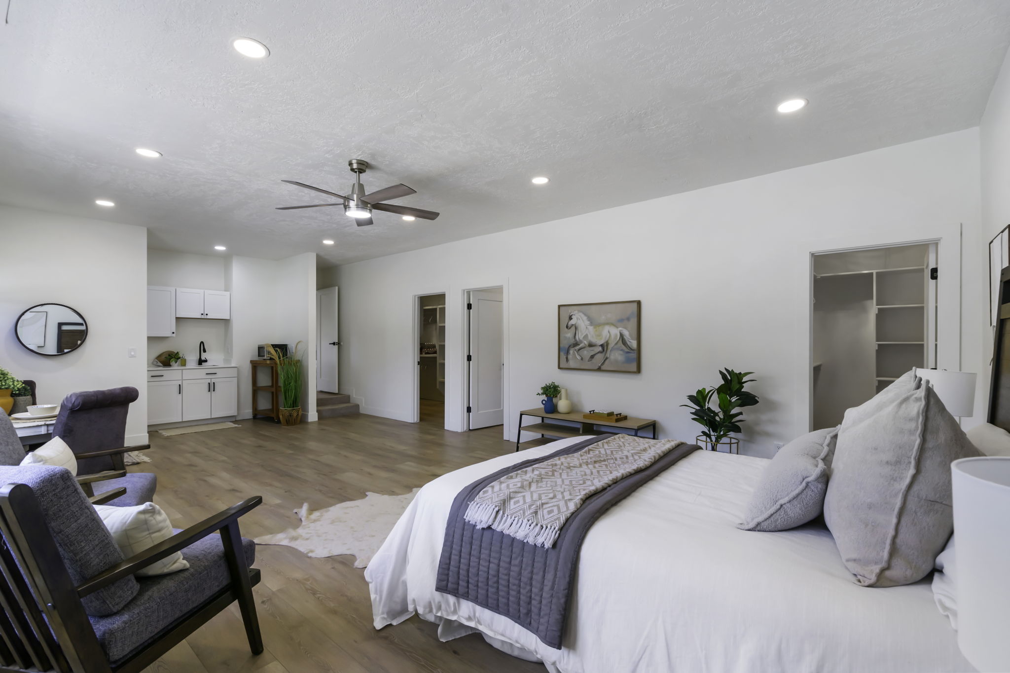 Spacious room featuring wood-finish flooring, recessed lighting, and a ceiling fan