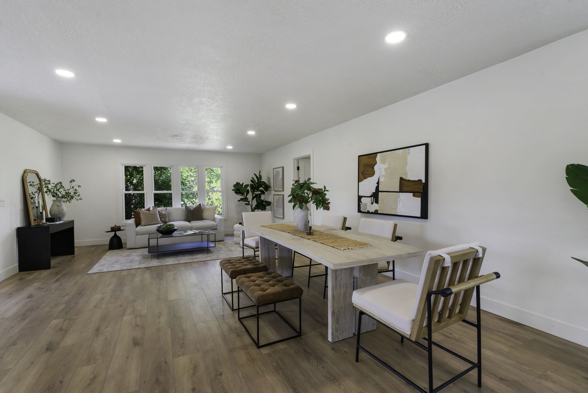 Open concept living and dining area featuring wood-finish flooring, recessed lighting, and white walls