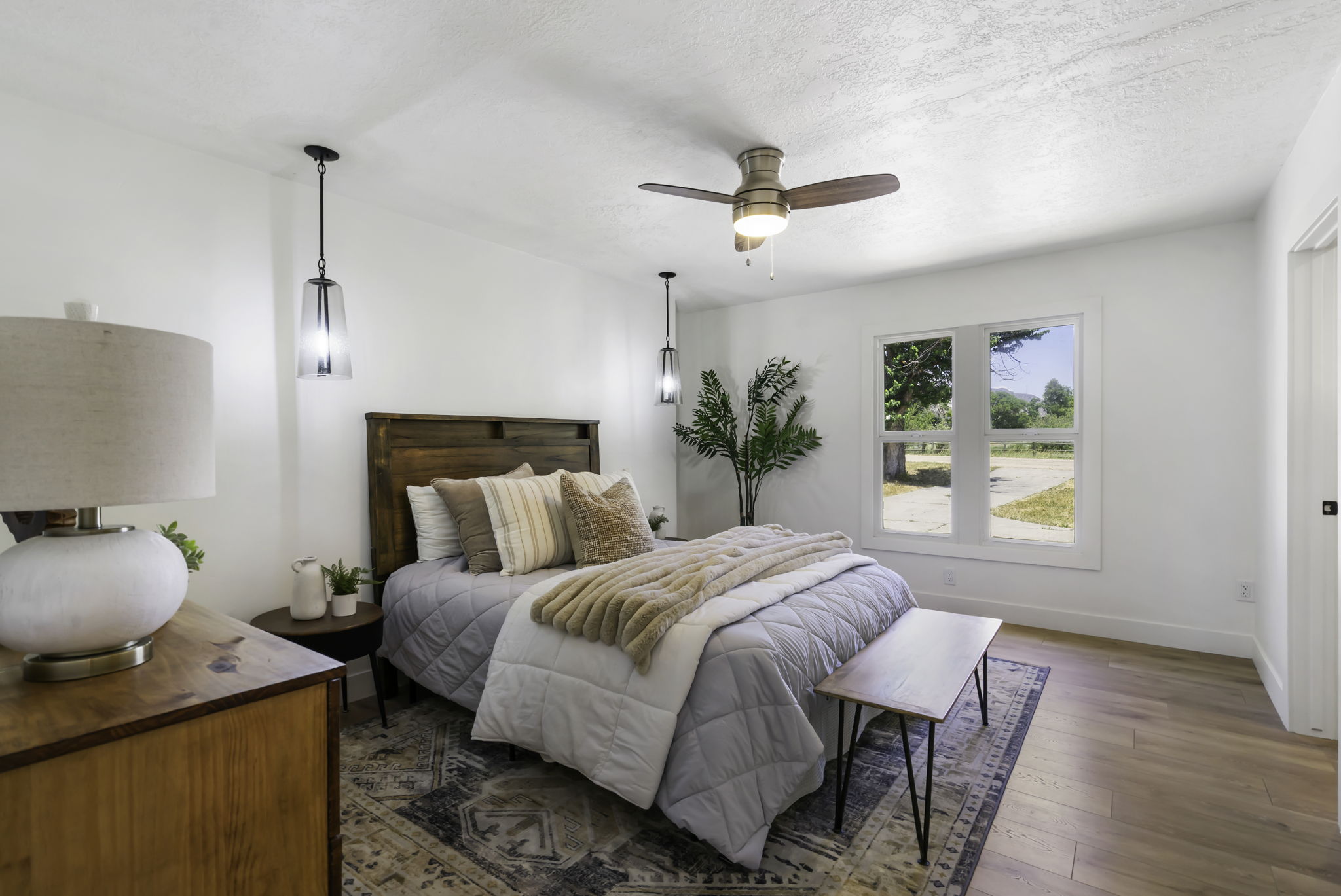 Bedroom featuring wood-finish flooring, a ceiling fan, and white walls