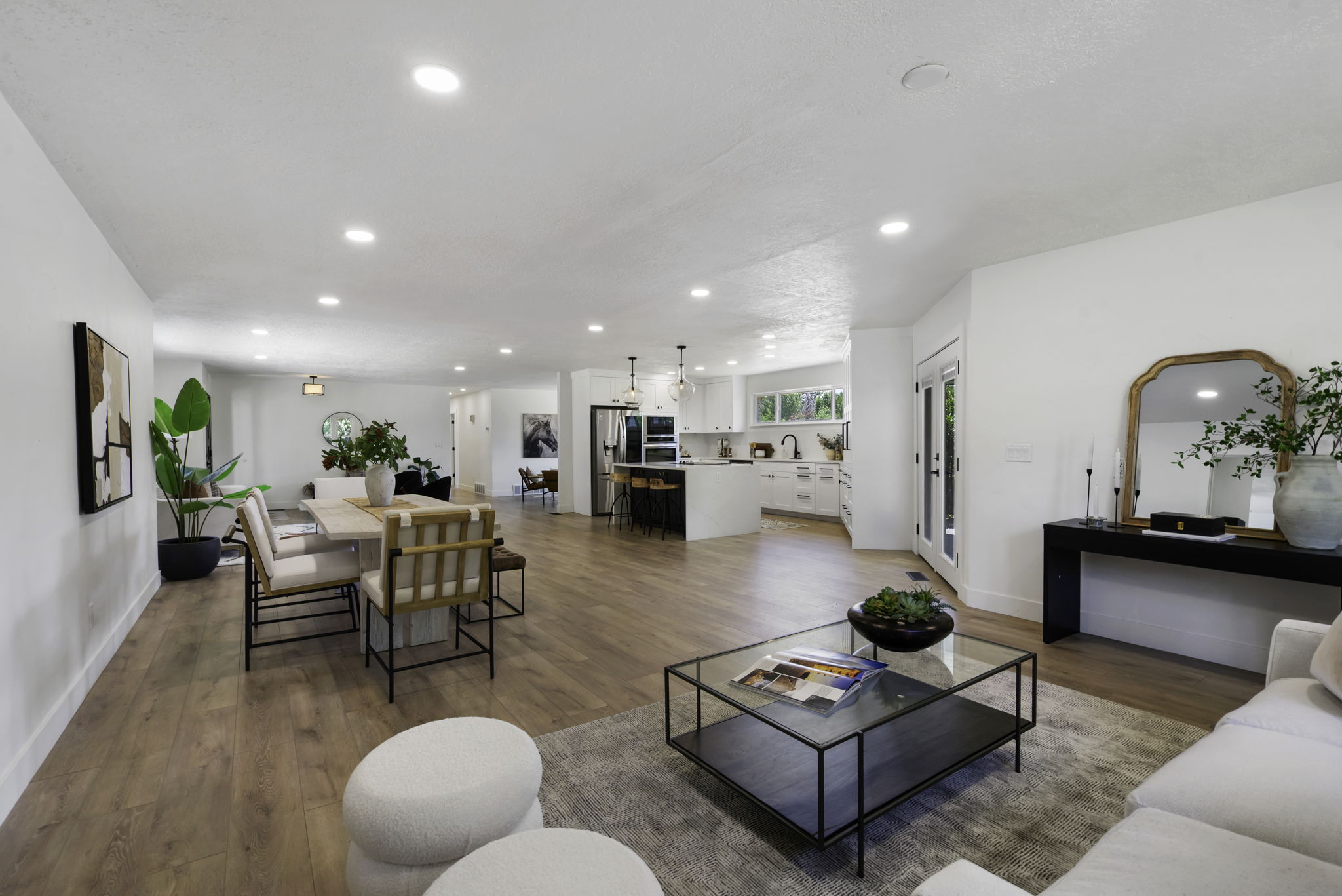 Open-concept living area featuring wood-finish flooring, recessed lighting, and white walls