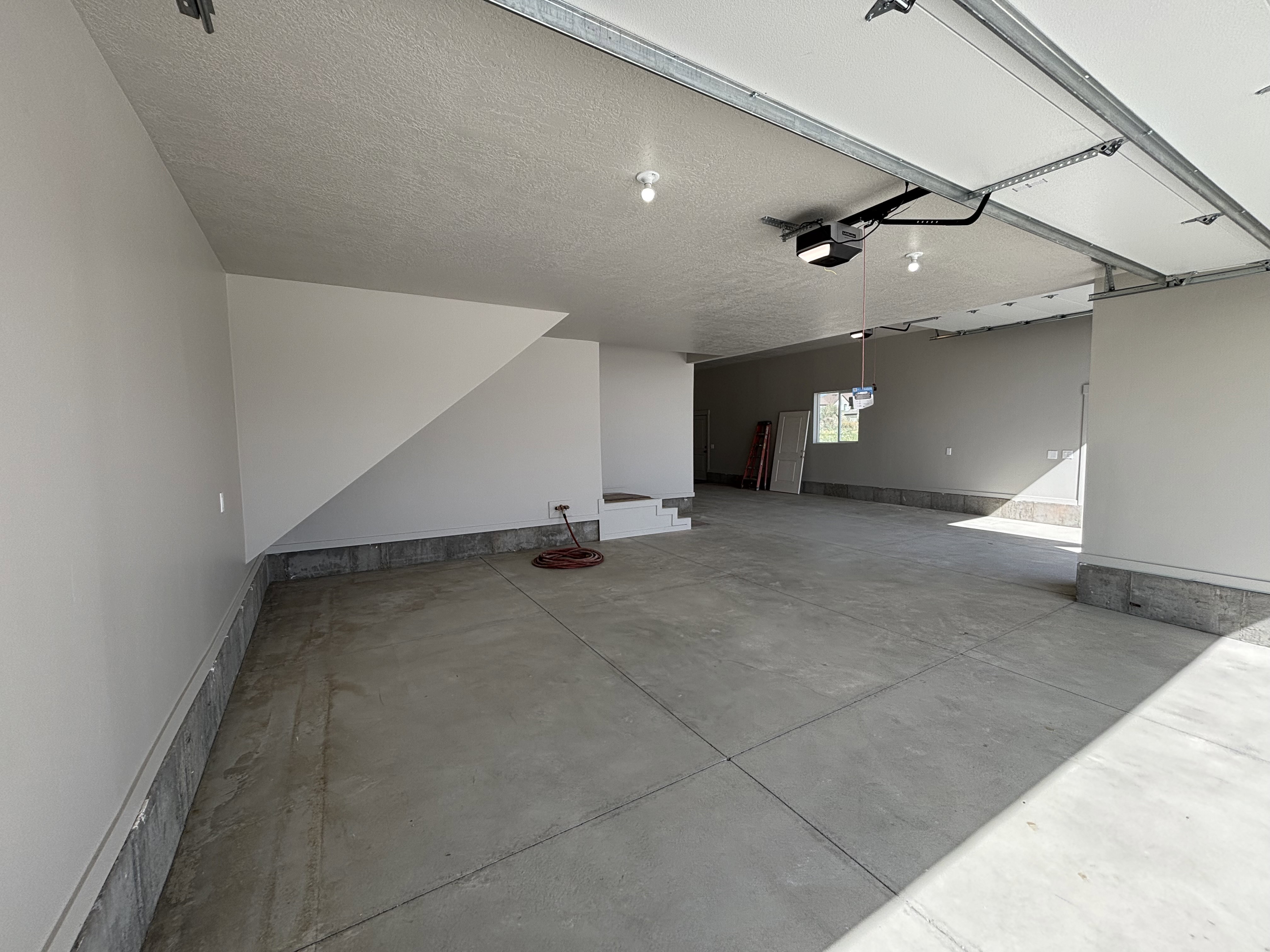 Spacious garage featuring a concrete floor, painted walls, and an automatic garage door opener