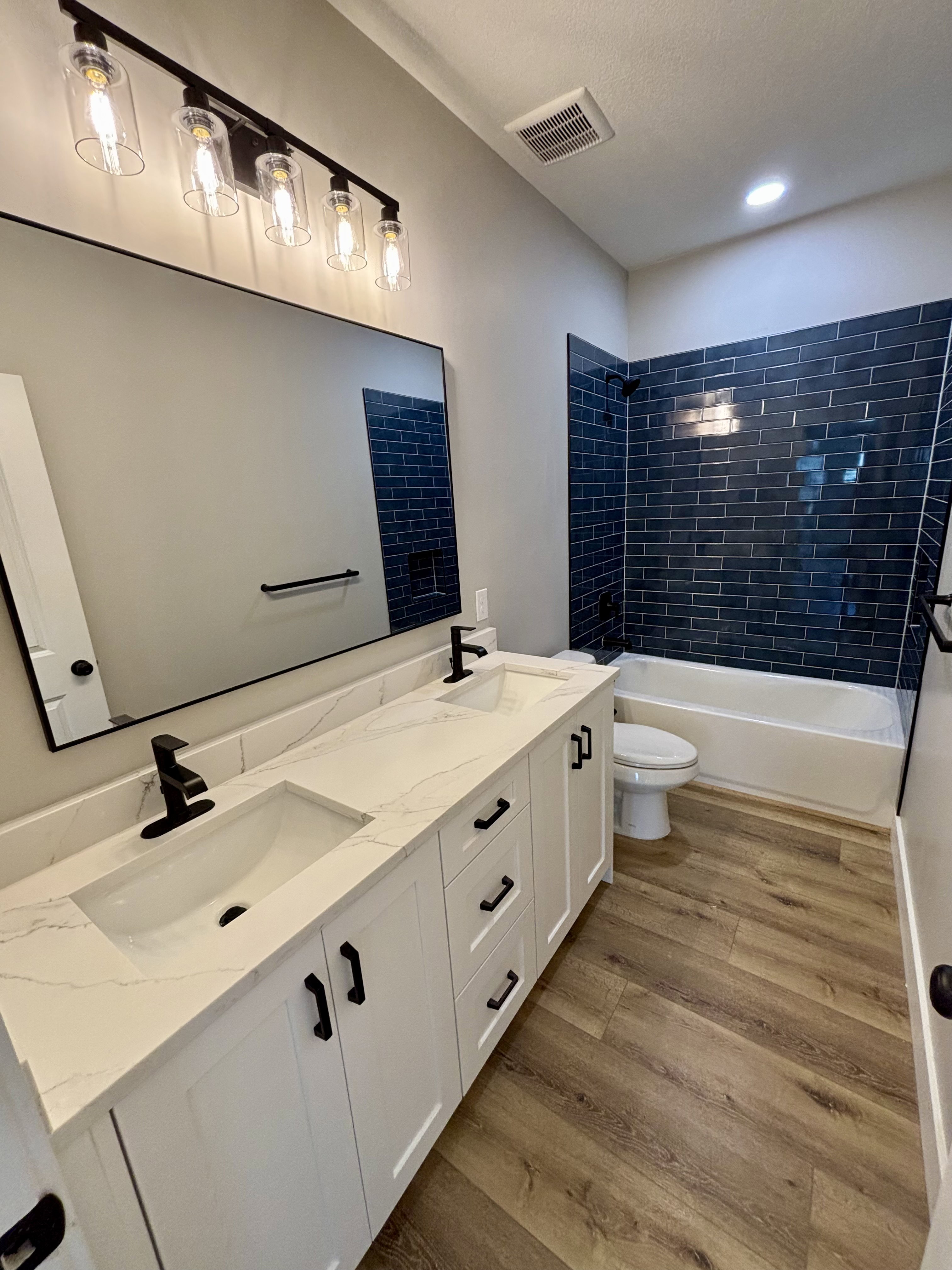 Main bath dual vanity with white cabinetry, quartz countertop, and integrated sinks