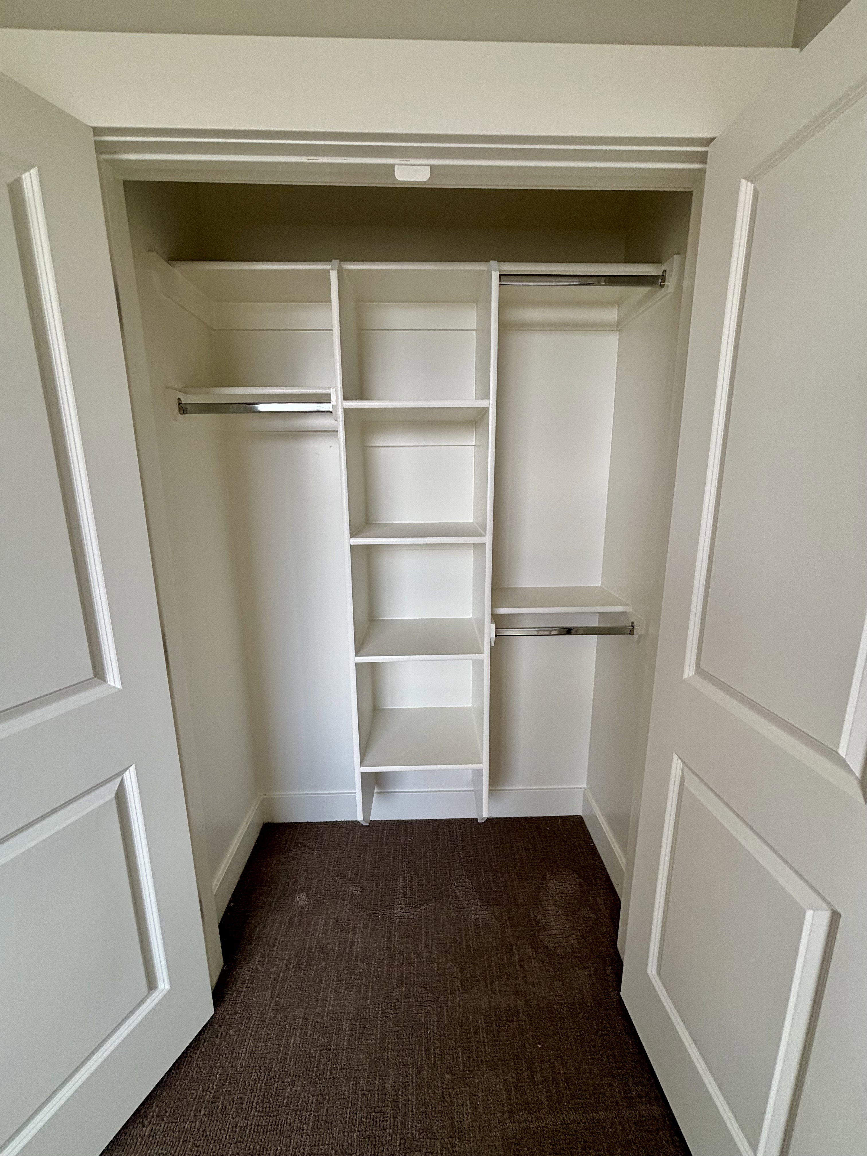 Integrated closet system featuring multiple shelves and hanging rods