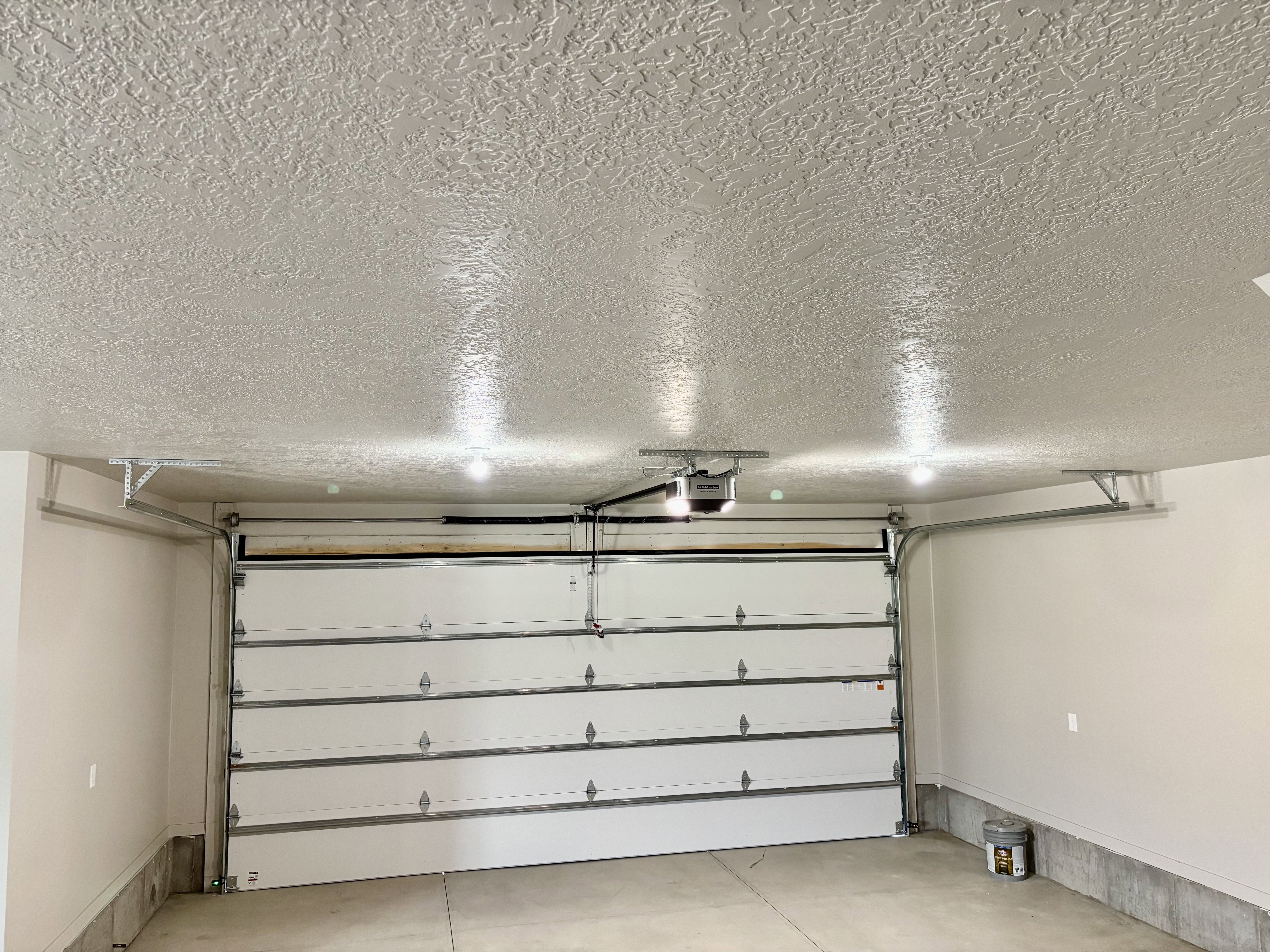 Attached garage featuring an automatic overhead door and fully finished walls/ceiling