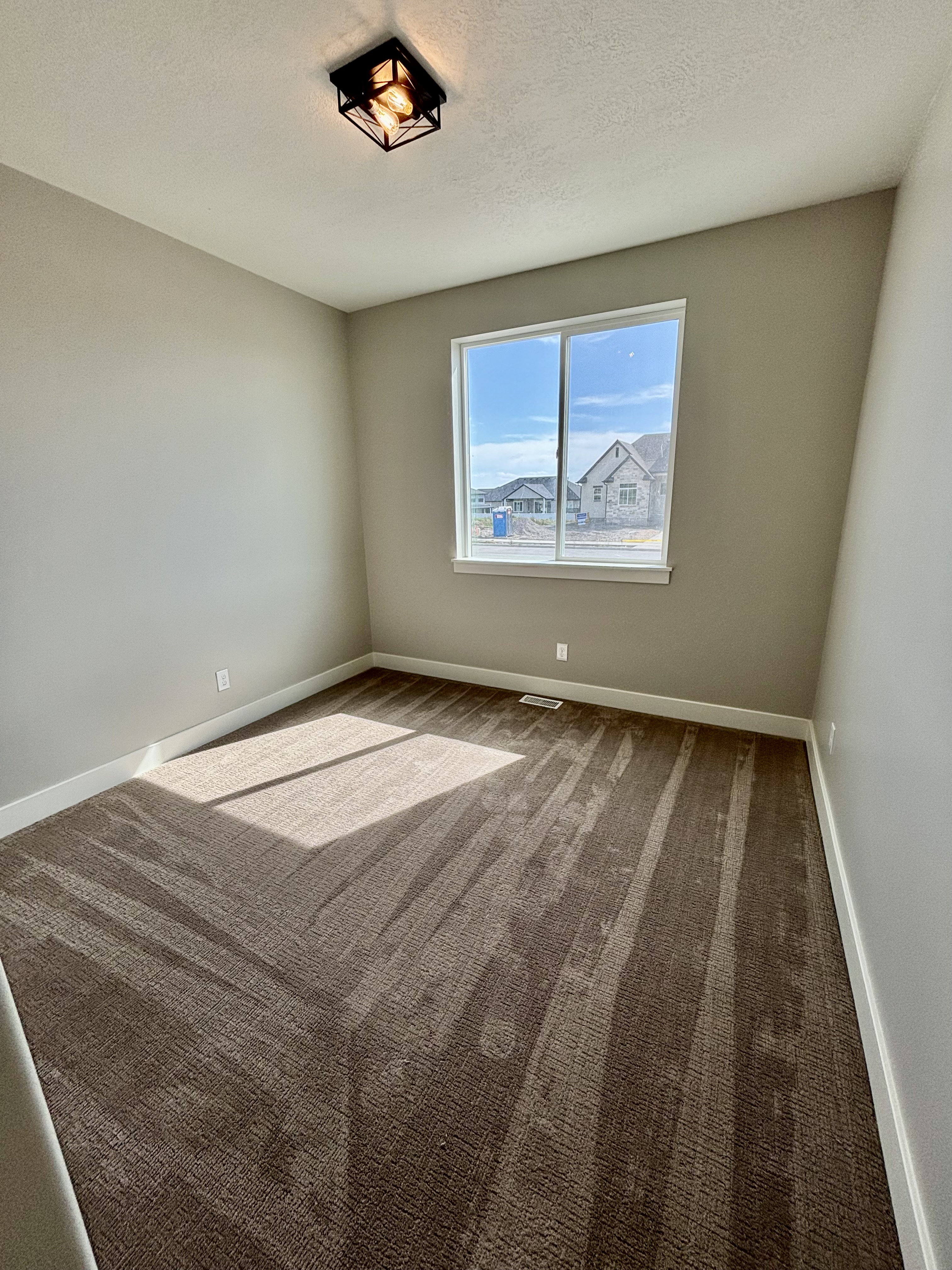 Bedroom featuring neutral wall paint, a double-pane window, and patterned carpet flooring