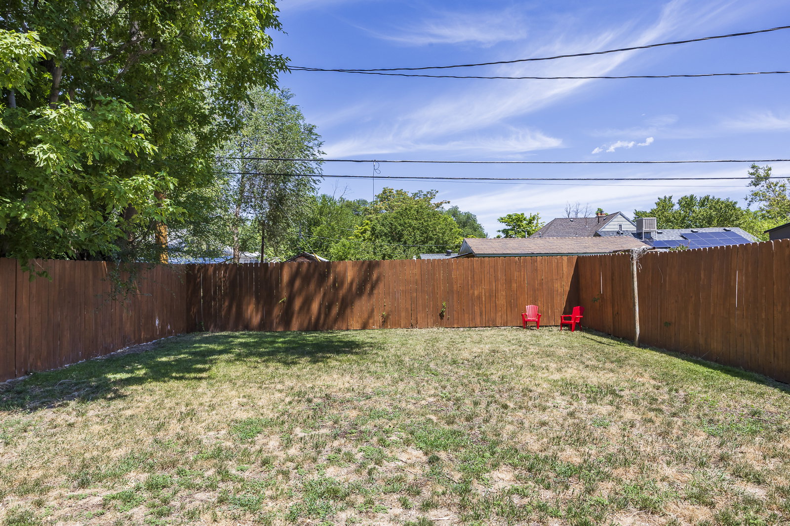 Expansive backyard featuring a full wood fence and mature perimeter trees