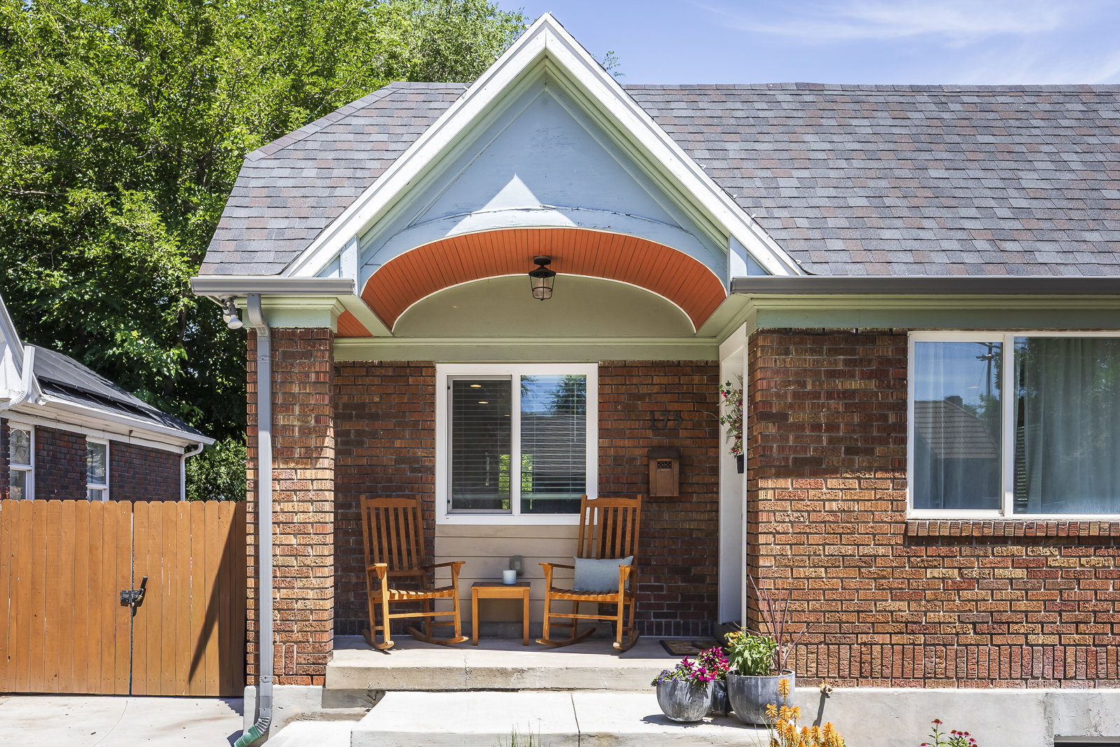 Brick exterior with a gabled entry featuring an arched soffit and prominent white trim