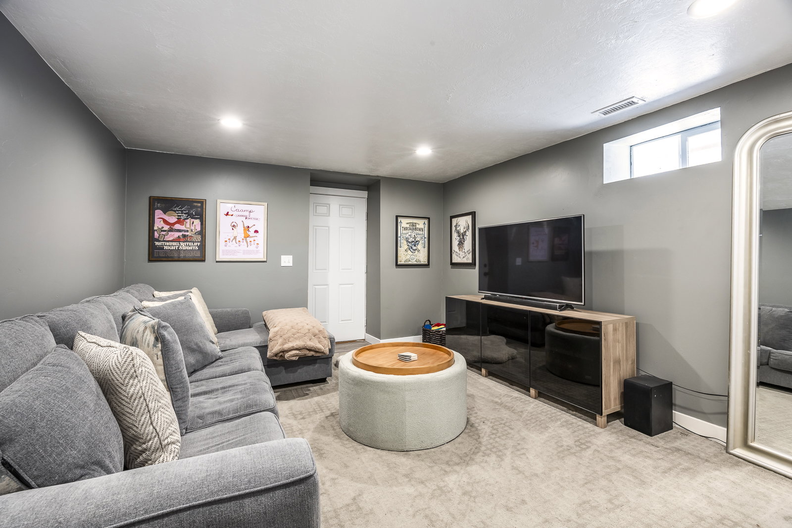 Recessed lighting illuminates this space featuring gray walls and light-toned carpeting