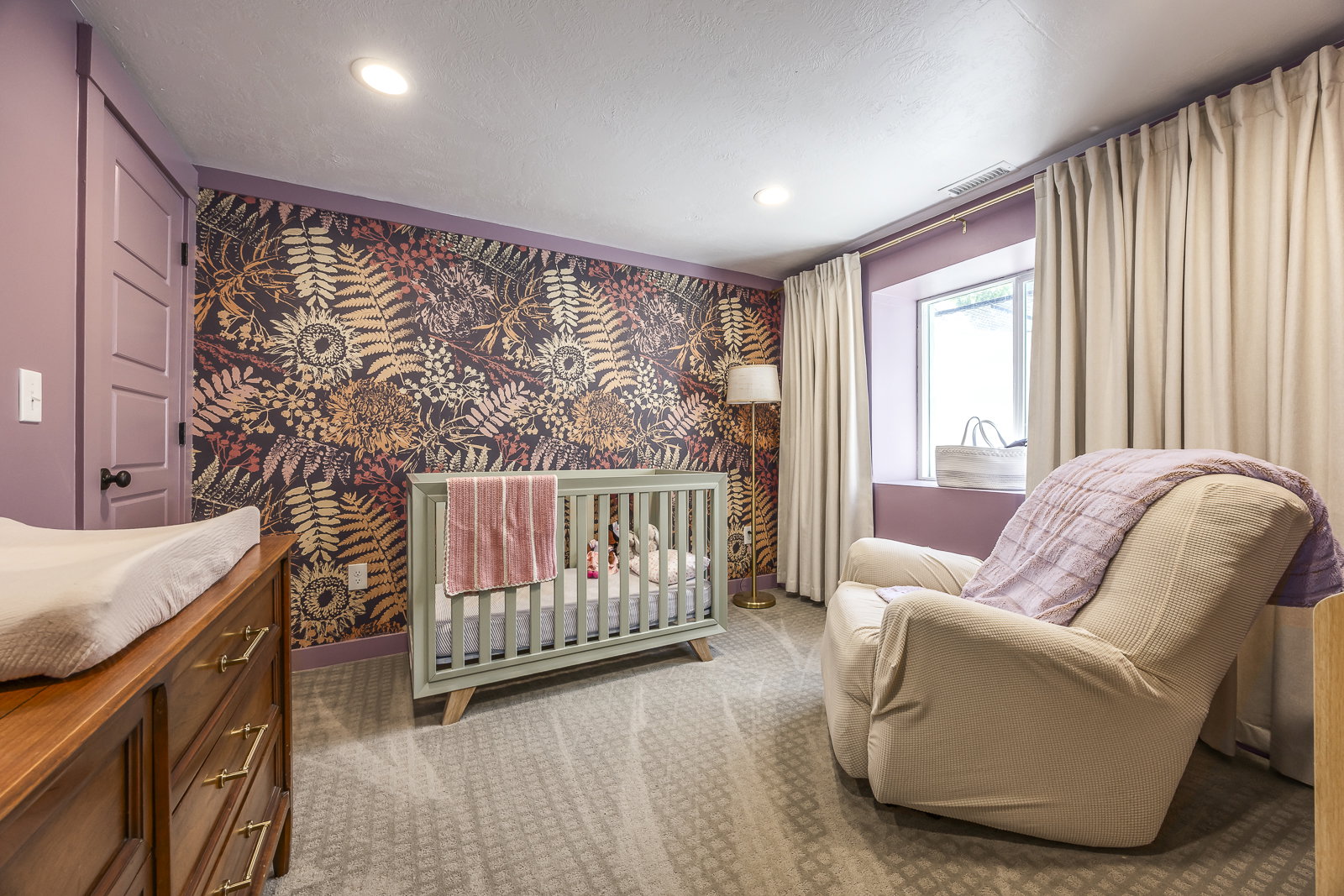 Room with patterned accent wall, recessed lighting, and light-colored carpeting