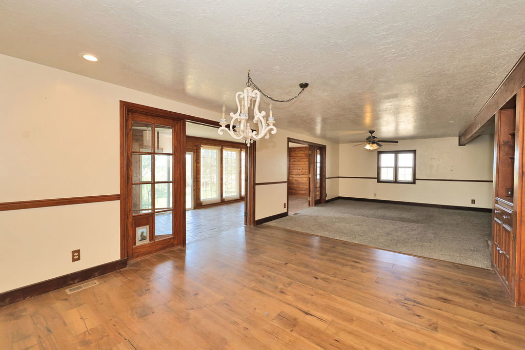 Spacious interior featuring wood-finish flooring, a decorative chandelier, and a wood-trimmed doorway