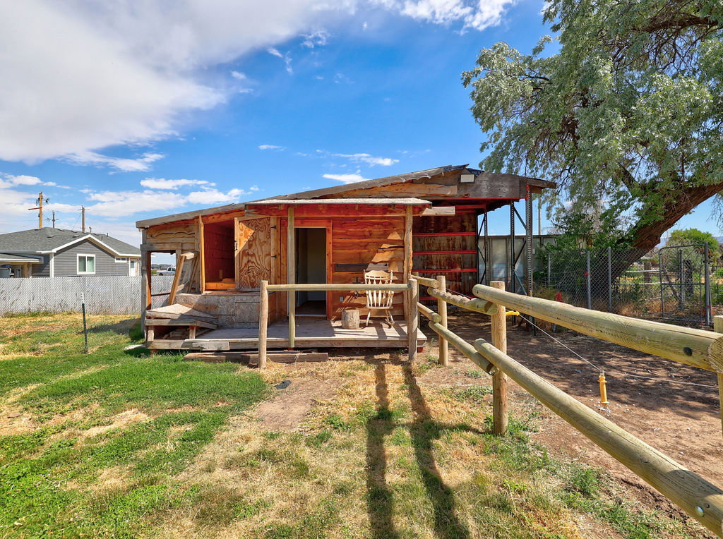 Rustic outbuilding with wood siding and an open front porch