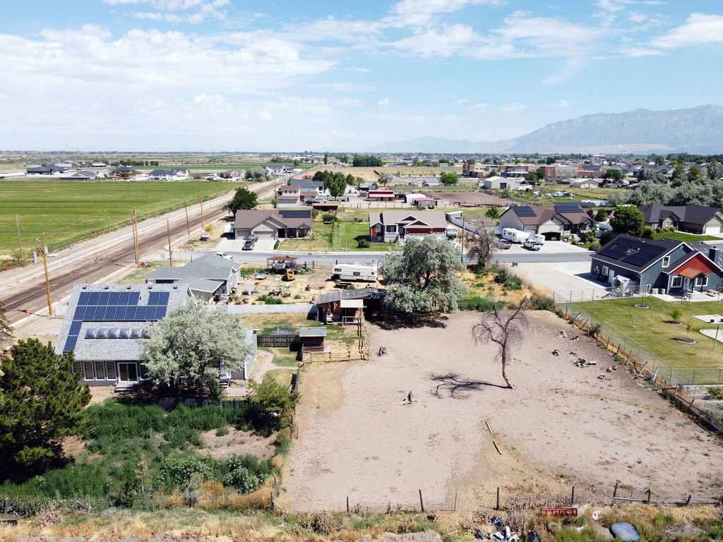 Expansive undeveloped lot featuring a single mature tree and perimeter fencing