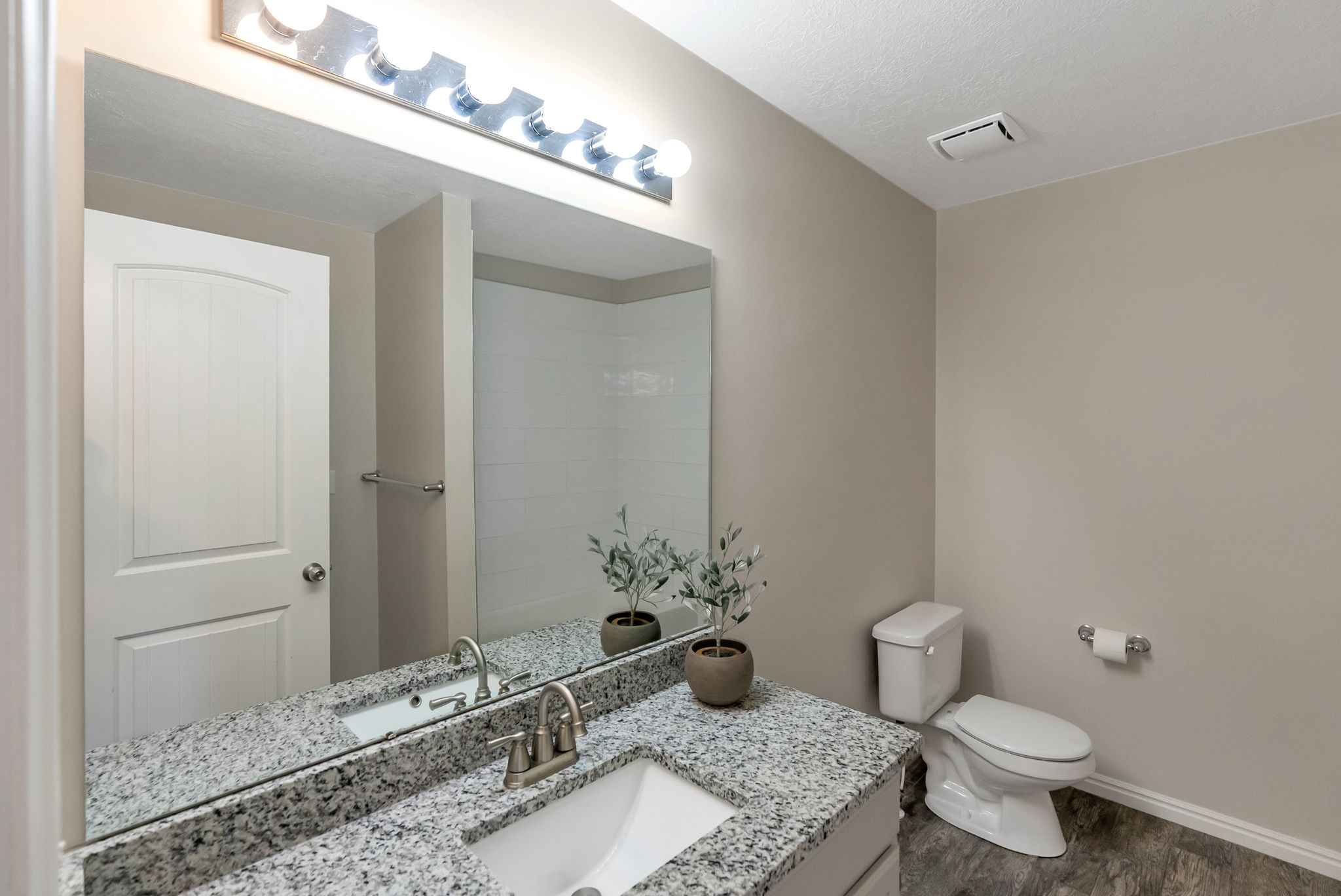 Bathroom featuring a granite-look countertop, undermount sink, and brushed nickel faucet