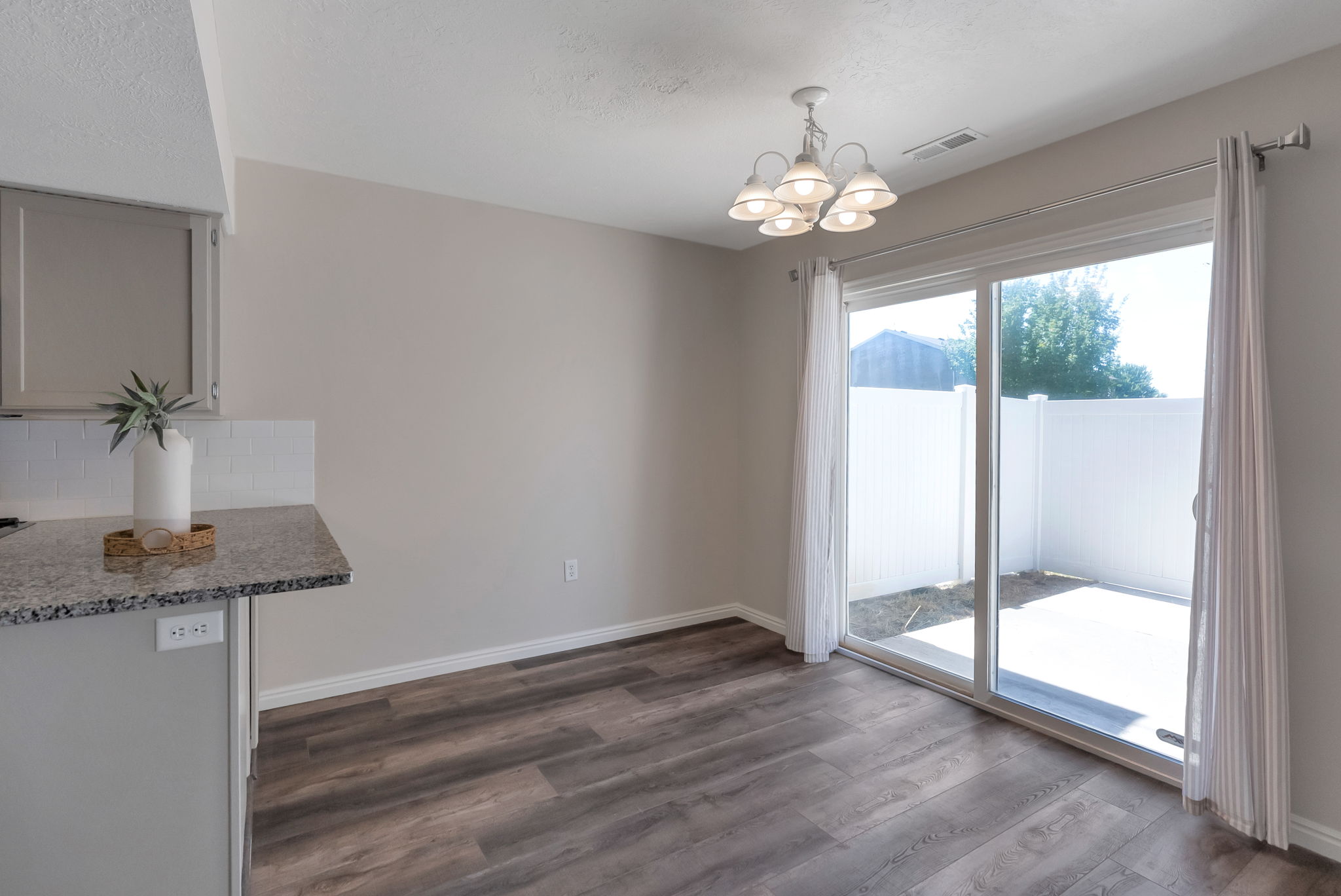 Dining area featuring wood-finish flooring and a contemporary chandelier