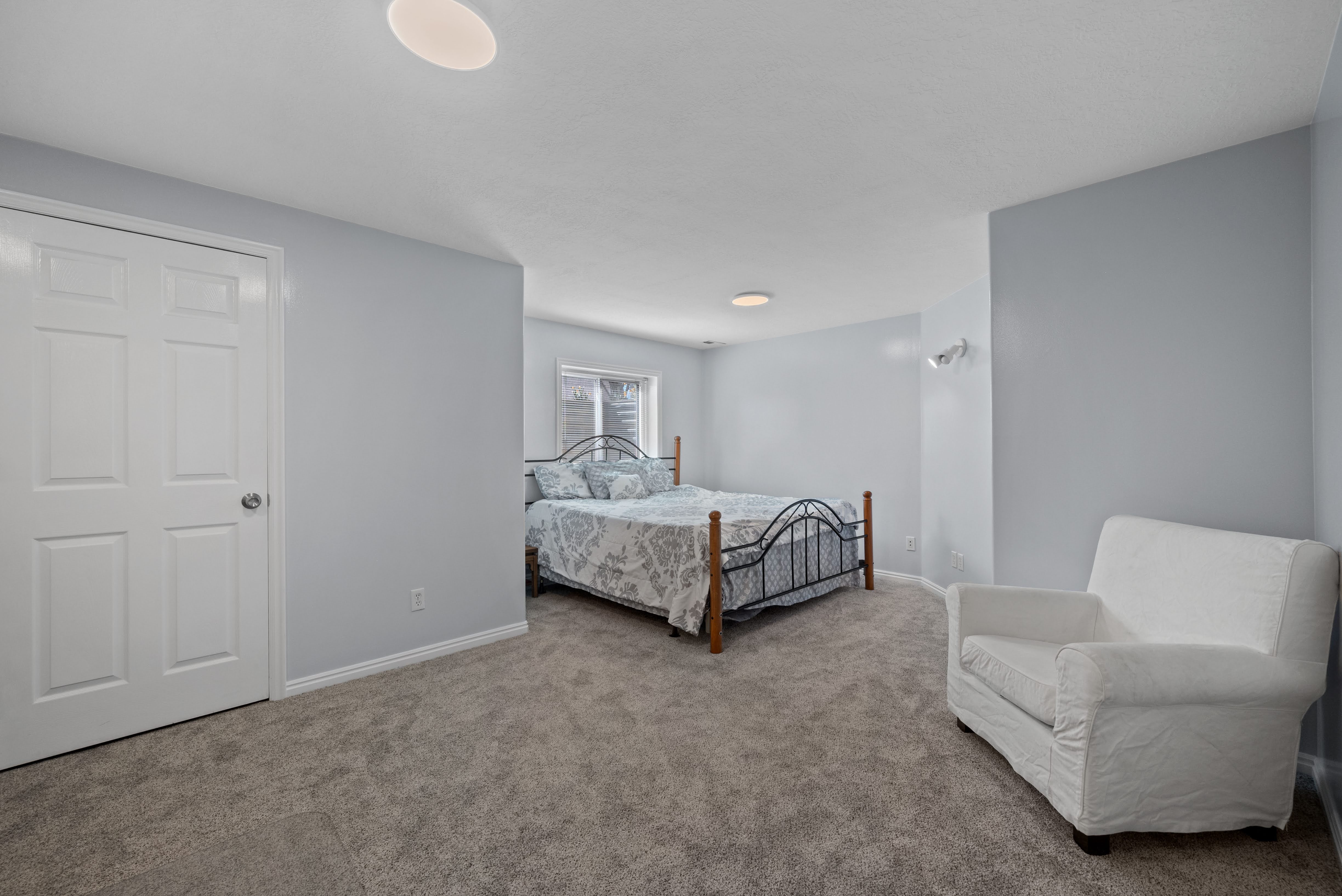Carpeted room featuring light blue walls, white trim, a multi-panel door, and a recessed window