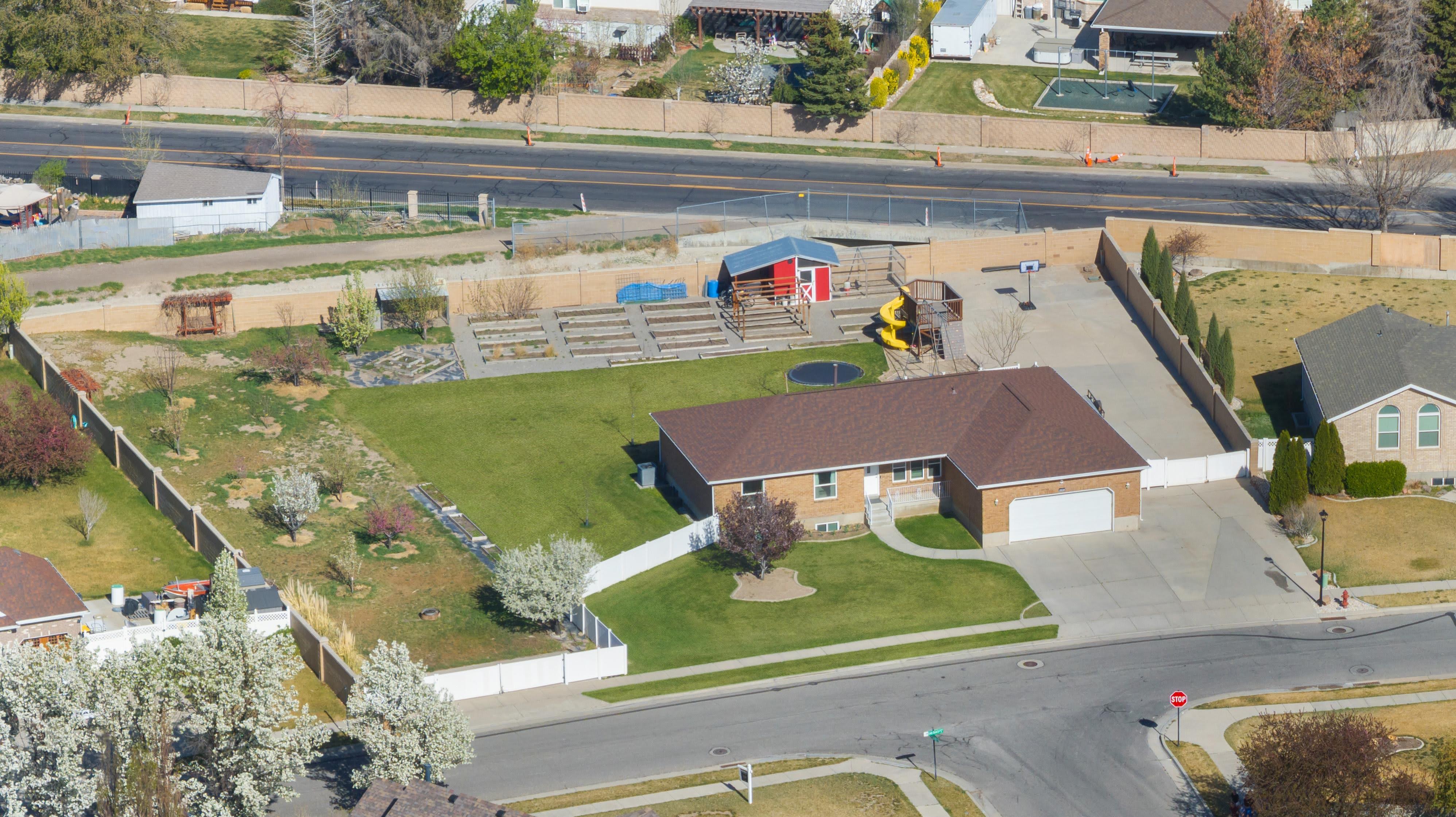 Single-story residence with an attached garage, featuring a large concrete driveway and a manicured front lawn
