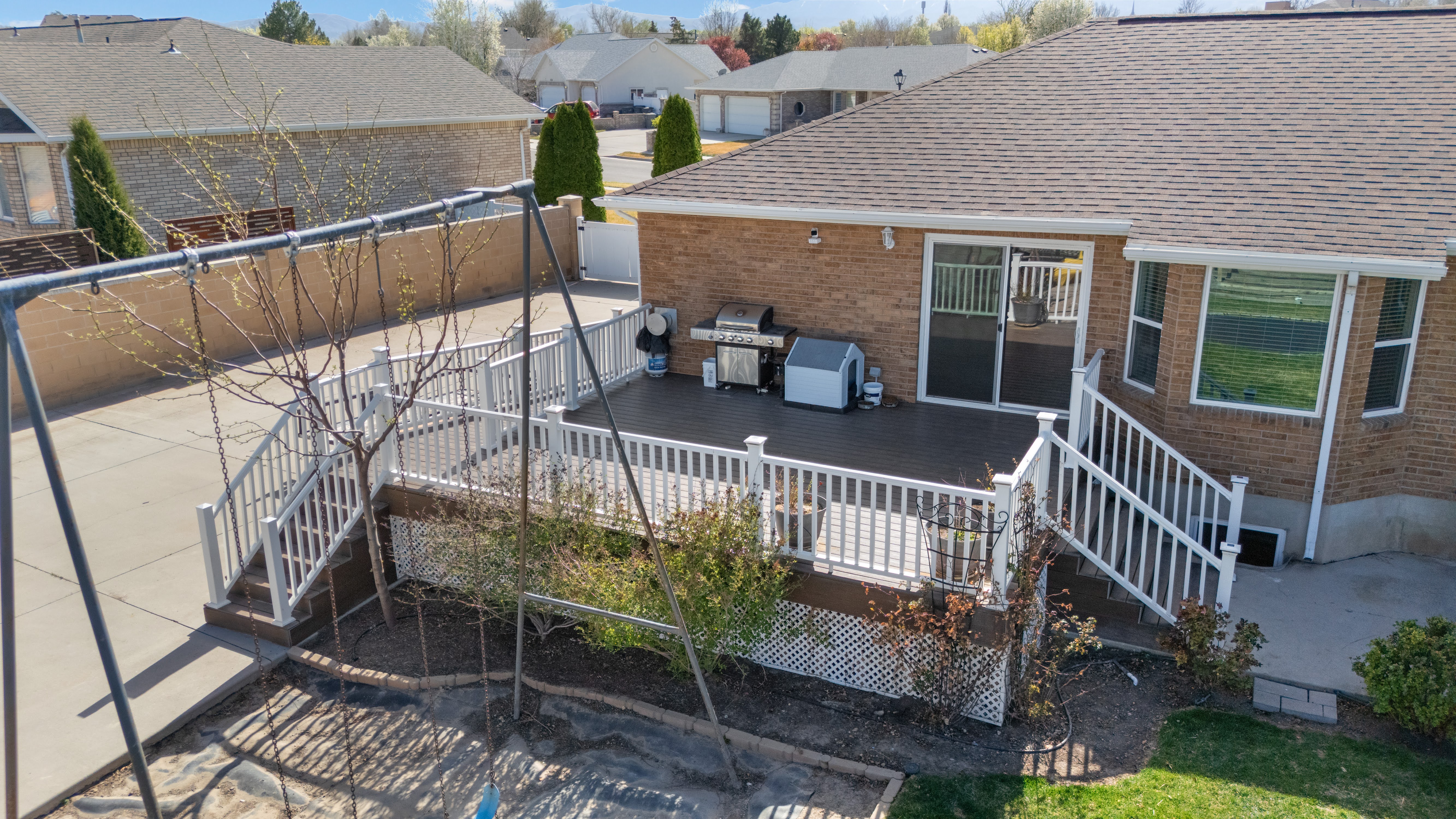 Multi-level deck with white railings and composite decking, accessed via sliding glass doors